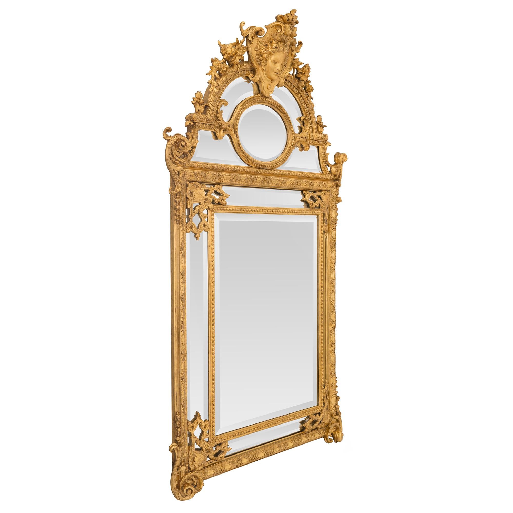 A striking French 19th century Régence st. double framed giltwood mirror. The mirror retains all of its original beveled mirror plates set within a fine beaded band and beautiful carved foliate designed frame. At each corner are impressive pierced