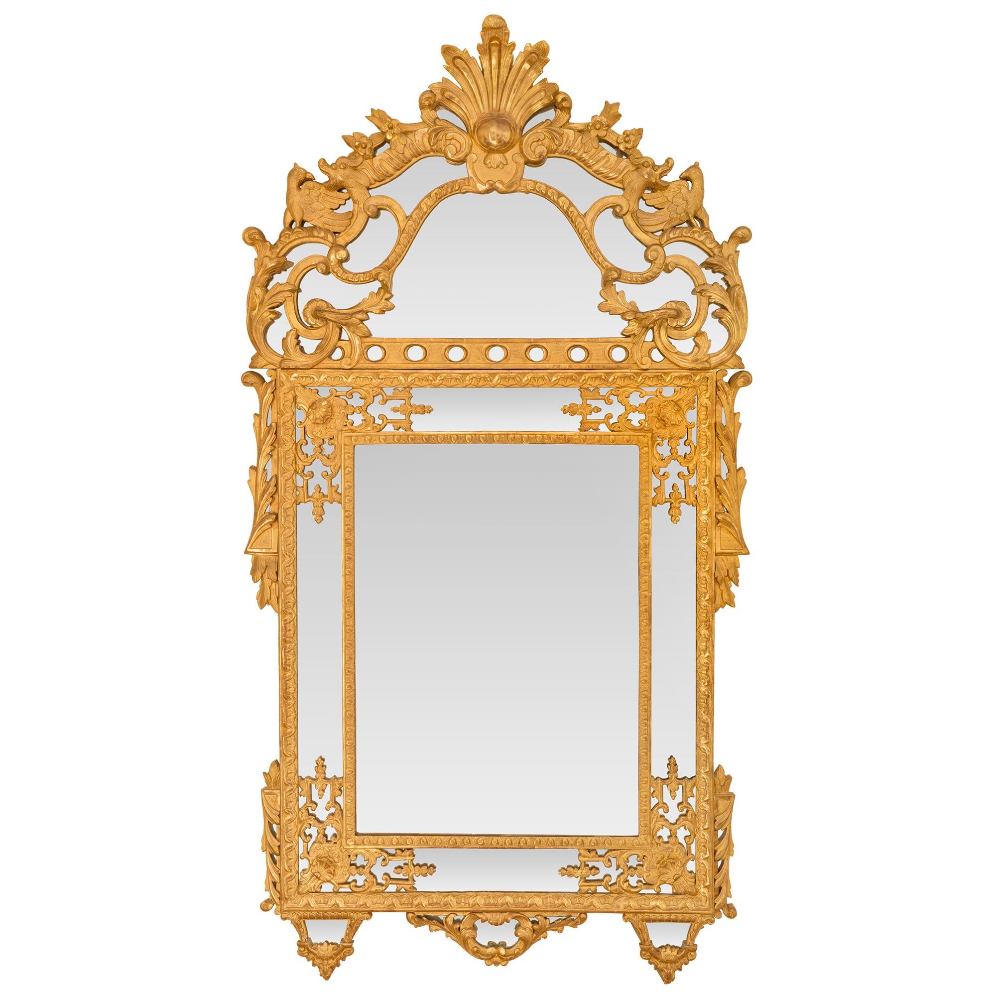 Ein beeindruckender und sehr hochwertiger französischer Rgence-Spiegel aus dem 19. Jahrhundert mit doppeltem Rahmen aus vergoldetem Holz. Der Spiegel ist durchgehend mit allen Originalspiegelplatten versehen, wobei die zentrale Platte von einem fein