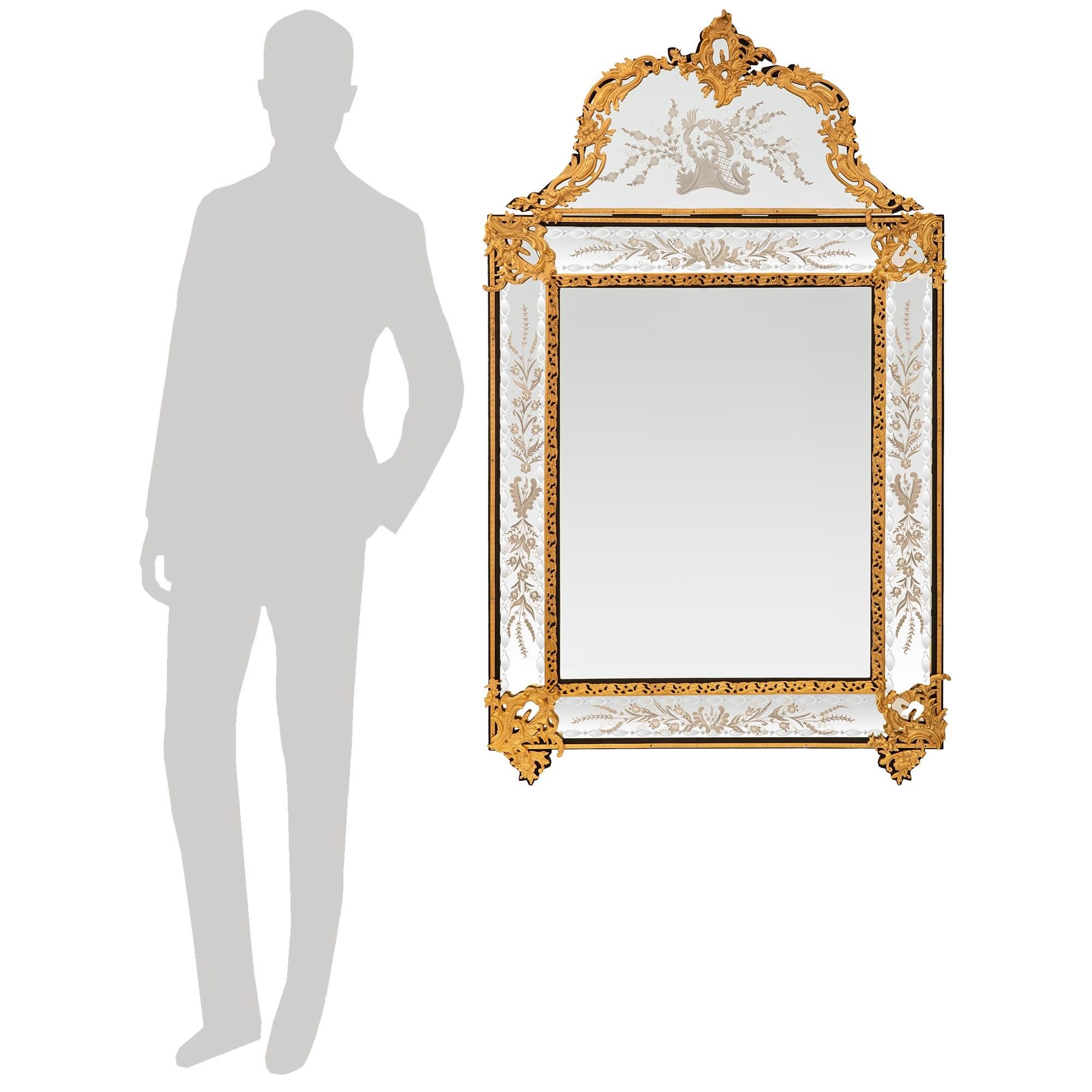 Excepcional y elegantísimo espejo de Ébano y Ormolu de la época de Napoleón III del siglo XIX. Este precioso espejo de doble marco está centrado por un borde interior de Ormolu calado que se acentúa en cada esquina con grandes monturas foliadas con