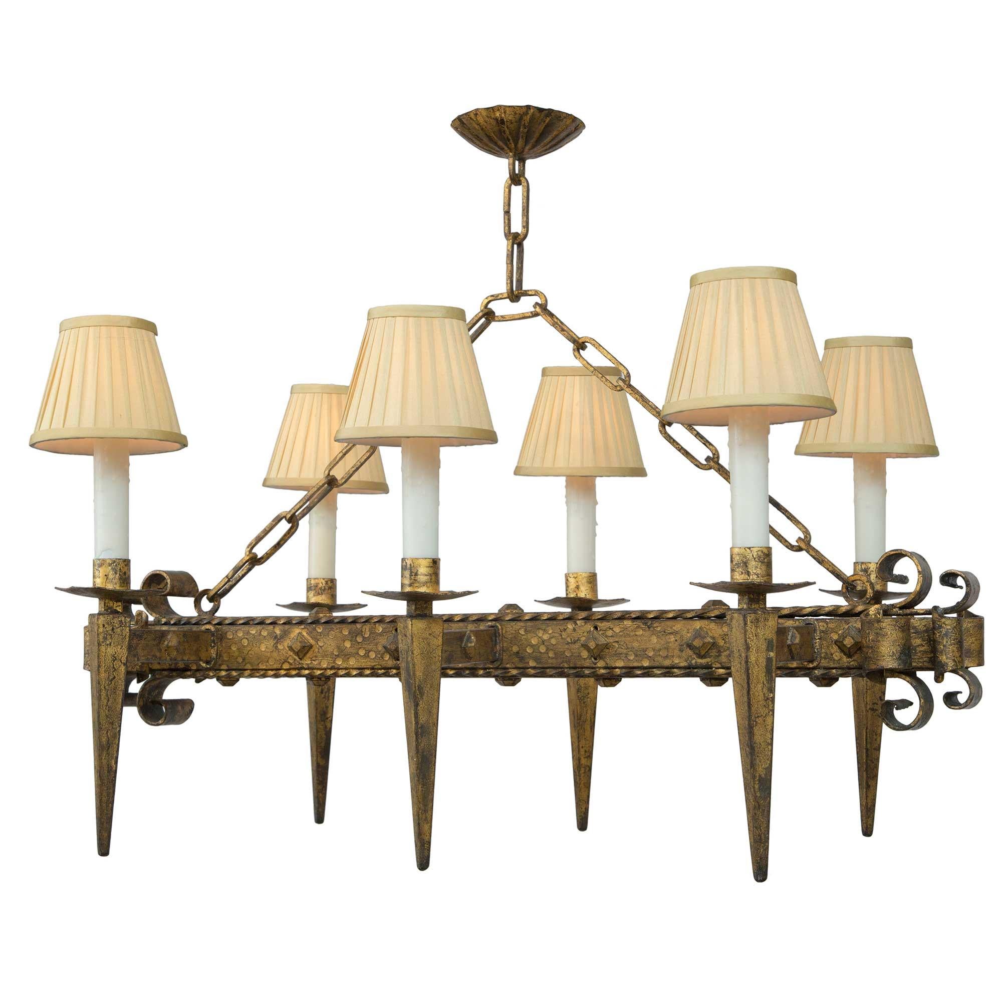 A handsome French 19th century Renaissance st. gilt iron six-arm chandelier. The rectangular-shaped chandelier has a square central hammered fut decorated by diamond-shaped buttons and twisted ribbon edges. The two end with wonderful and decorative