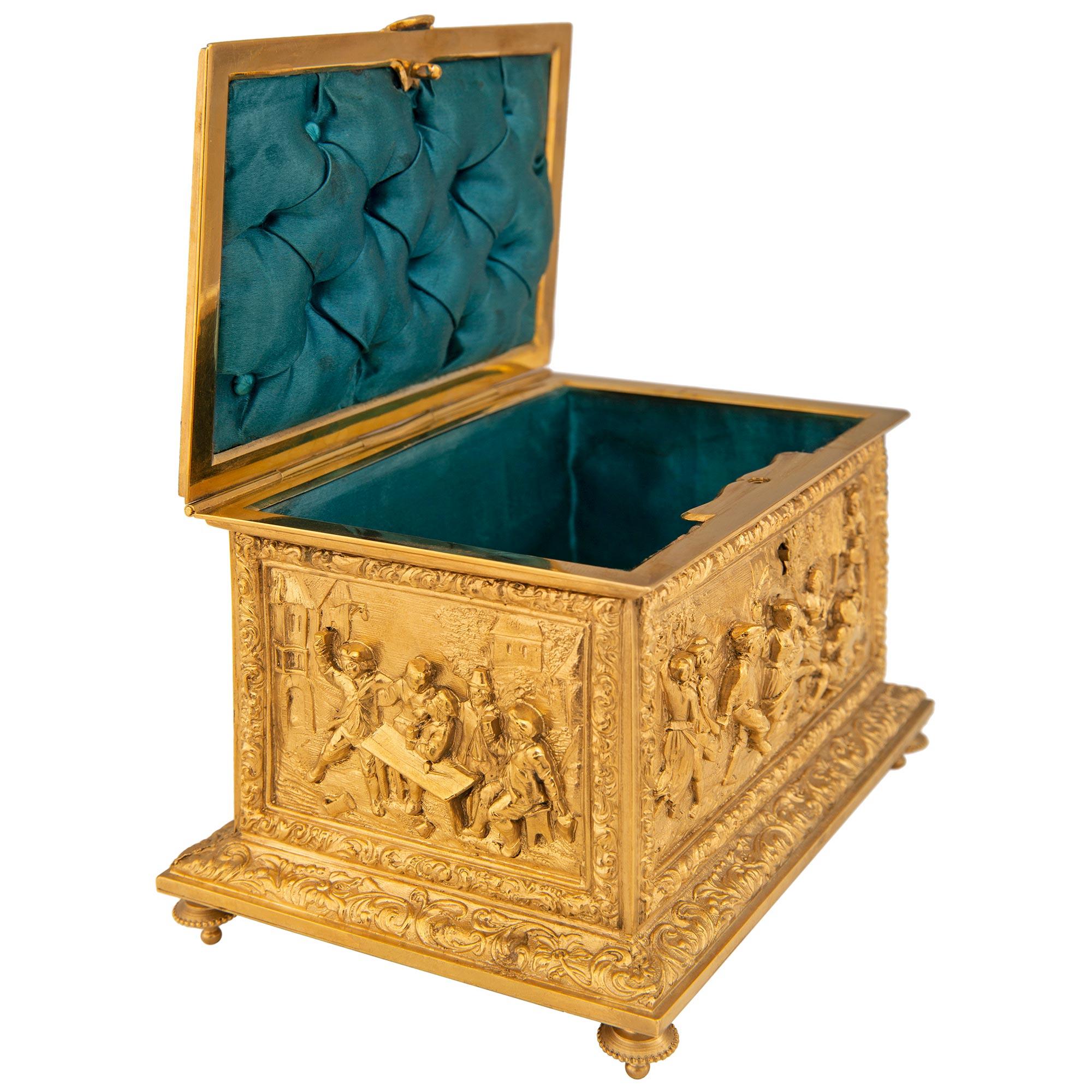 Étonnante boîte à bijoux en bronze doré de la Renaissance du XIXe siècle, signée A.B. Paris. Ce magnifique coffret est surélevé par quatre pieds en forme de topie montés sous une base rectangulaire ornée de rinceaux sur tous les côtés. Au-dessus de
