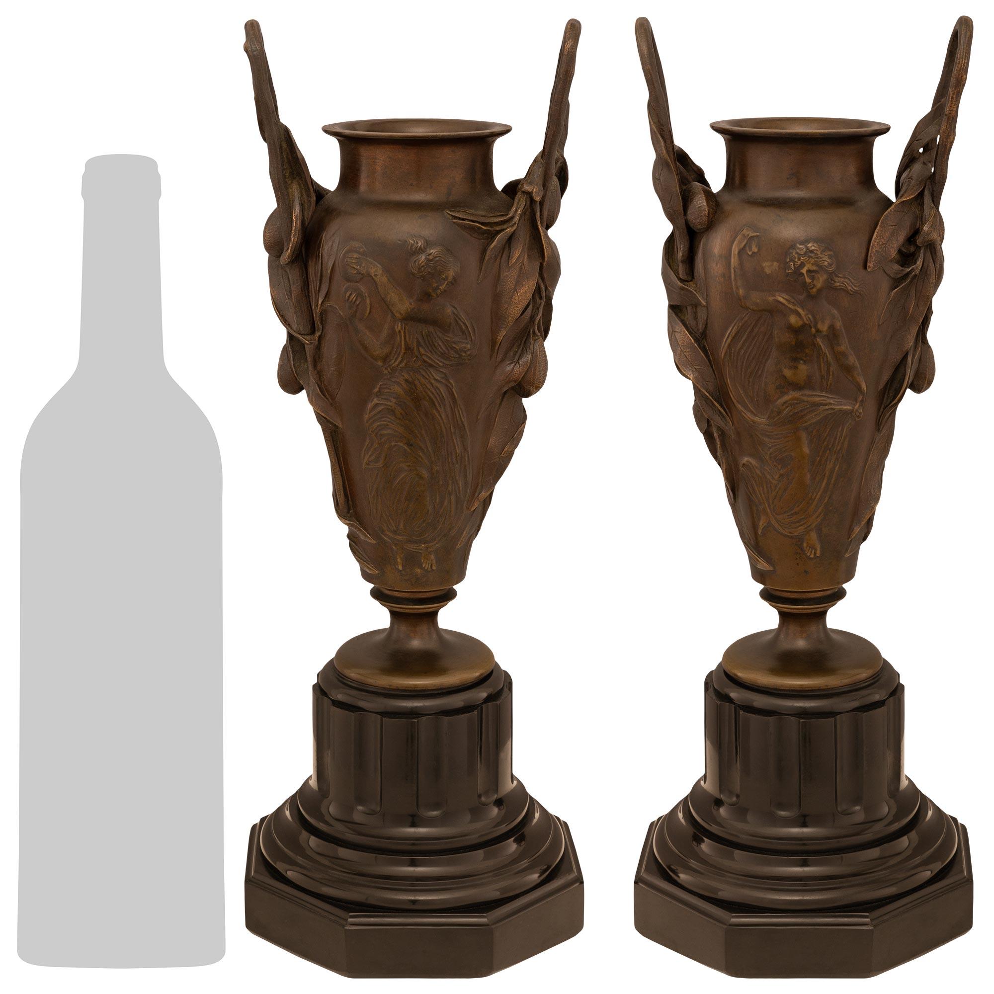 Magnifique paire d'urnes en bronze patiné et marbre noir de Belgique de style Renaissance du XIXe siècle. Chaque urne est posée sur une base octogonale en marbre noir de Belgique au design tacheté et aux motifs cannelés. Les urnes ci-dessus