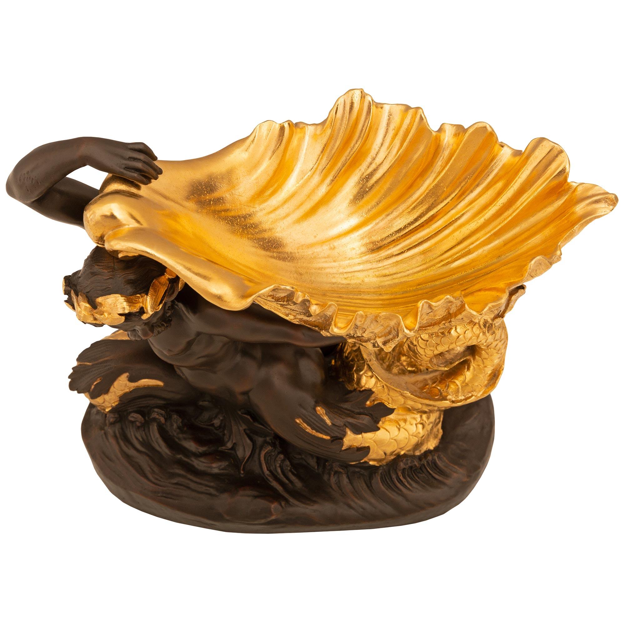 Une très belle urne en bronze patiné et bronze doré de style Renaissance du 19ème siècle. L'urne est surélevée par une base ovale avec un homme en bronze patiné nageant au-dessus des vagues. Les écailles merveilleusement détaillées de sa queue sont