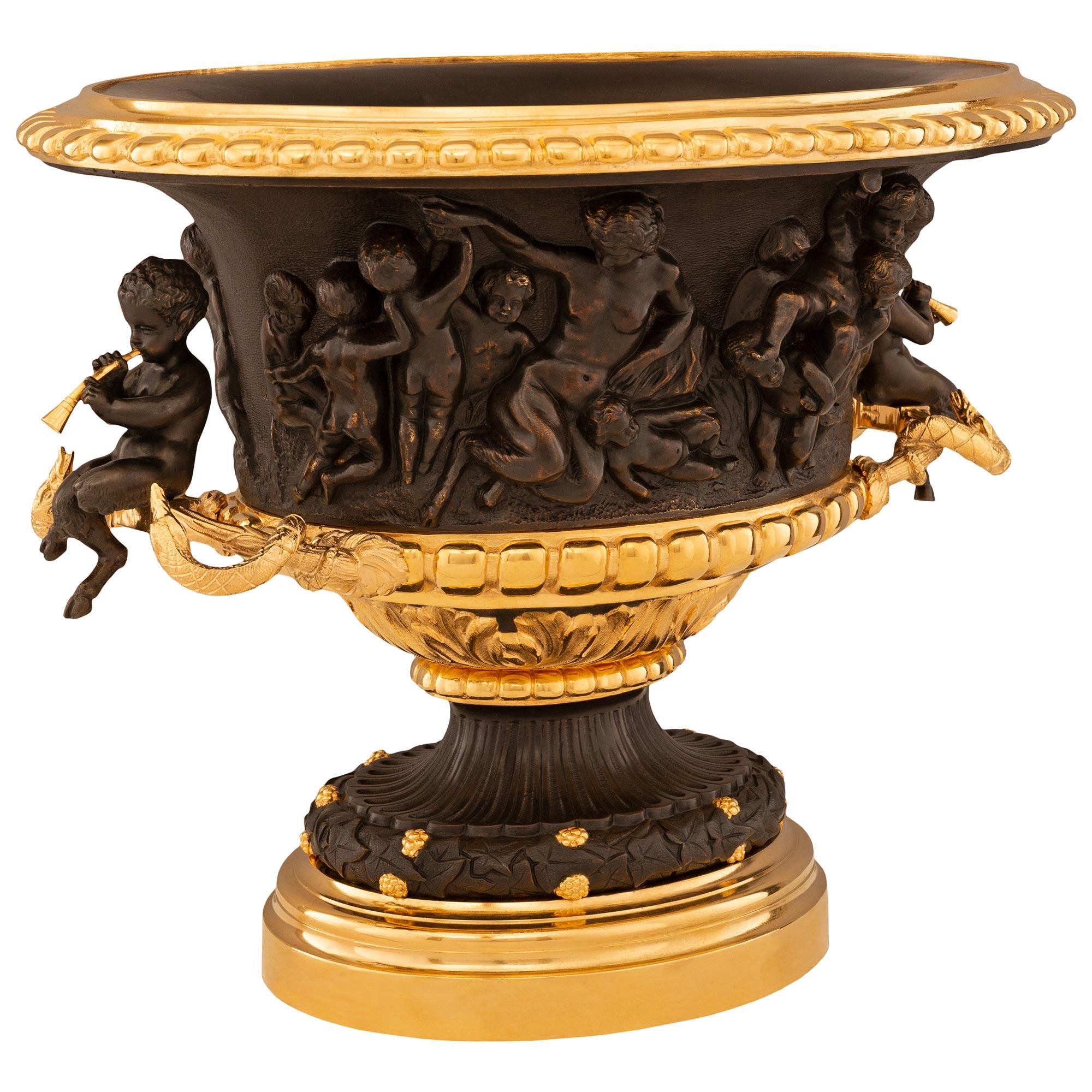 Ein eleganter und hochwertiger französischer Tafelaufsatz aus patinierter Bronze und Ormolu aus dem 19. Diese wunderschön detaillierte Urne wird von einem runden, gesprenkelten und abgestuften Ormolu-Sockel getragen. Über dem Ormolu-Sockel befindet