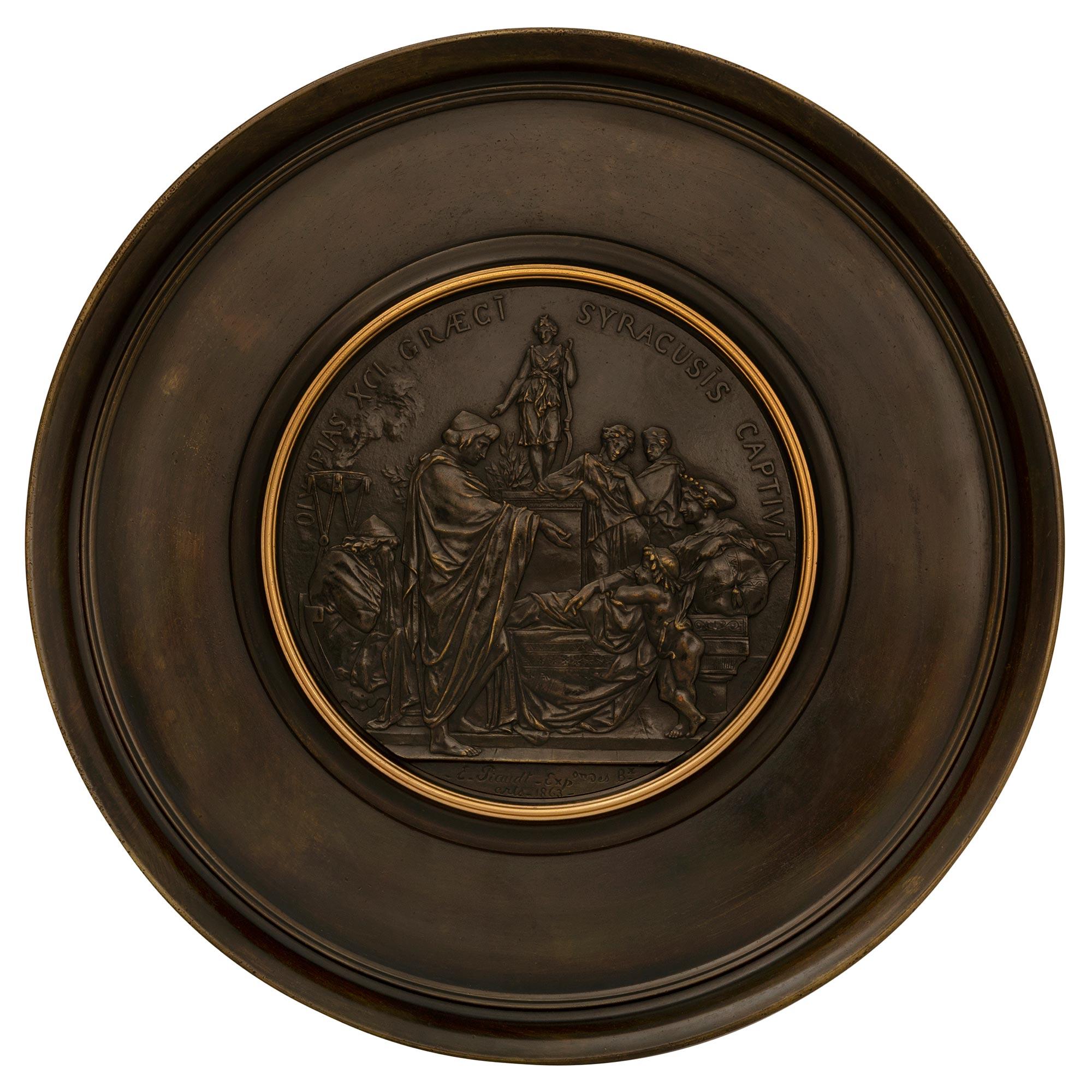 Très beau tazza français du milieu du 19e siècle, de style Renaissance, en bronze patiné et doré. Elle repose sur une base tripode dont les supports à volutes en 