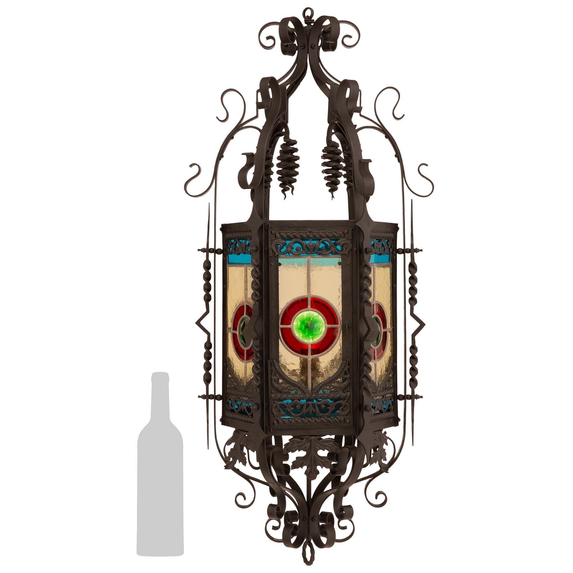 A high quality and most decorative French 19th century Renaissance st. Wrought Iron and Stained Glass lantern. This beautiful six window lantern is centered around the bottom finial of a spiraling Wrought Iron ring. Above the finial is an array of