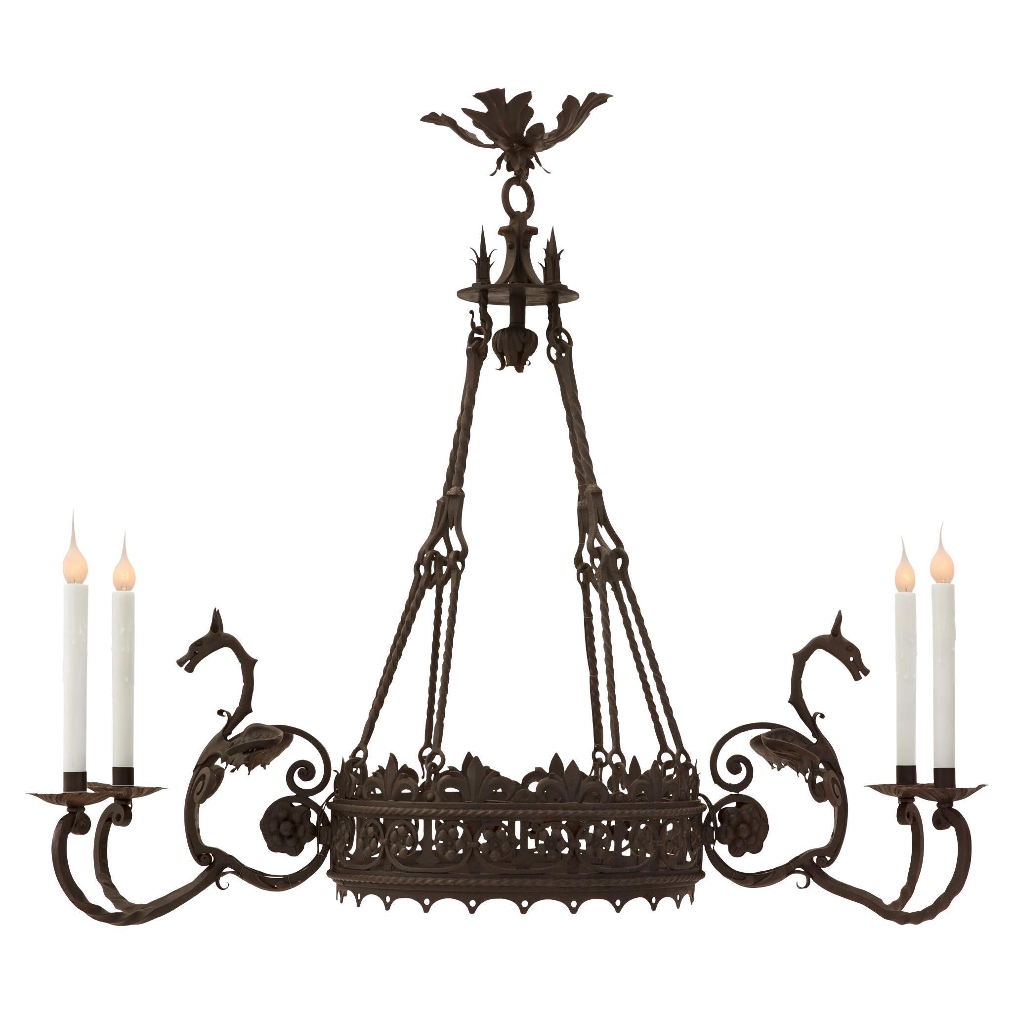 A striking and unique French 19th century Renaissance st. wrought iron chandelier. The four light oblong shaped chandelier is centered by a charming bottom floral finial below the circular central support displaying beautiful pierced scrolled