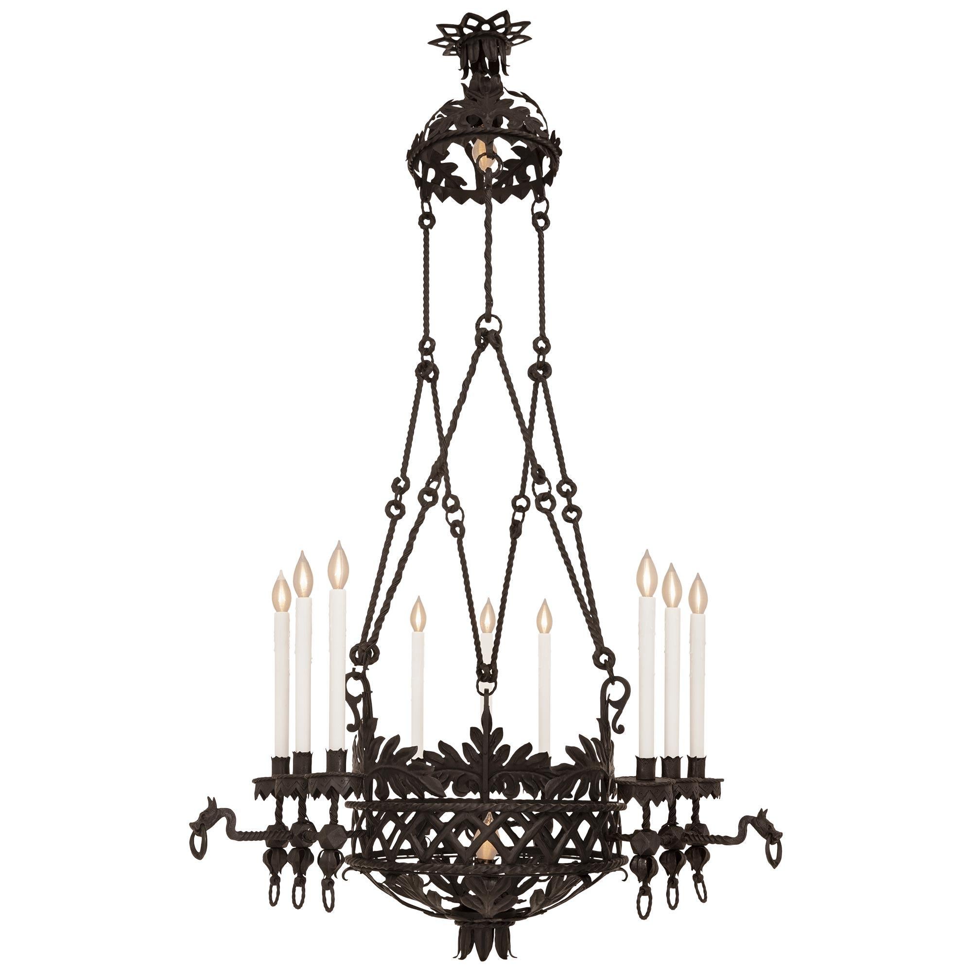 A large scaled French 19th century Renaissance st. Wrought Iron chandelier. The eleven light chandelier has a bottom half round foliate decorated dome with a central bottom finial and a bottom interior light bulb. The dome leads upwards to a lattice