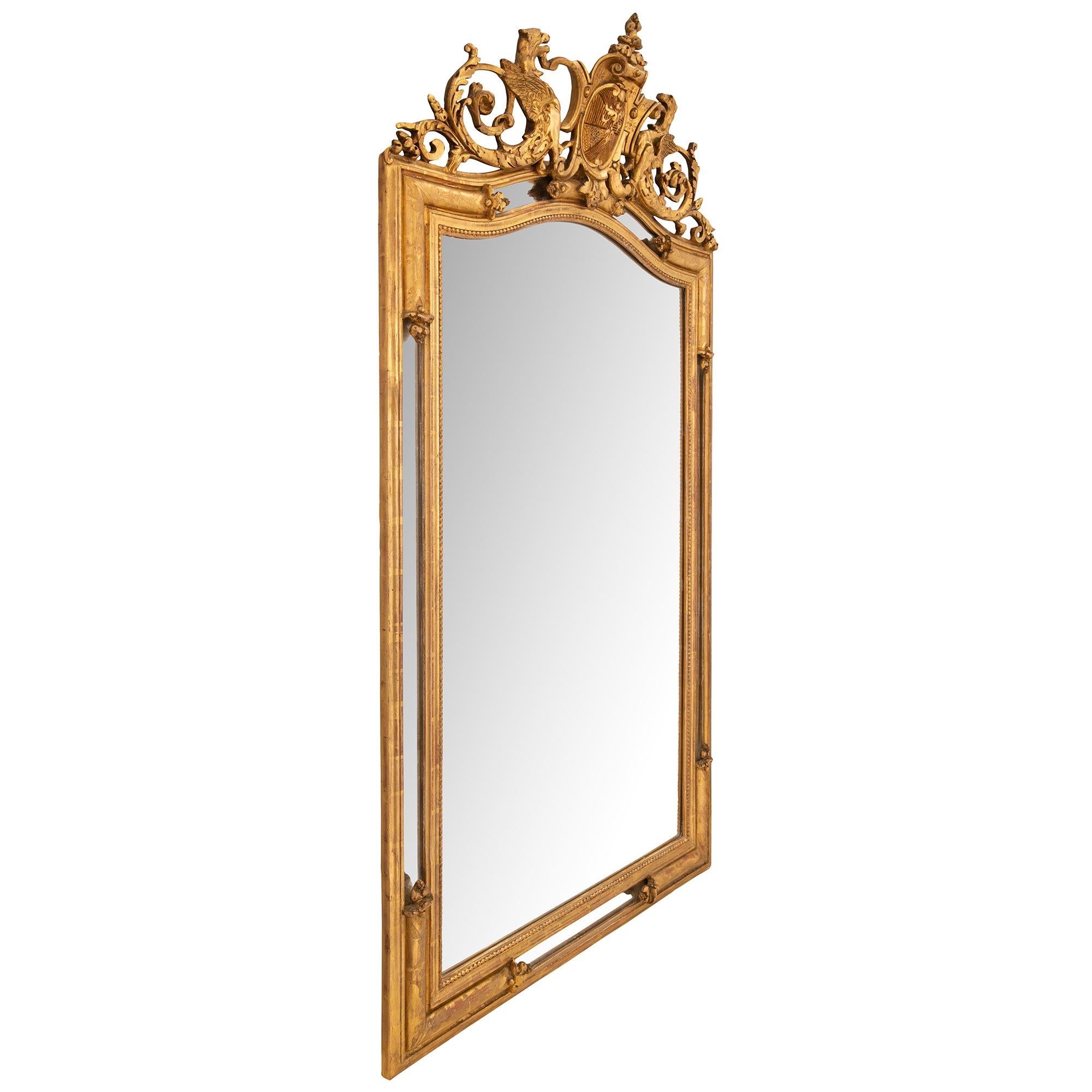 An attractive French late 19th century Renaissance St. double frame giltwood mirror. The rectangular mirror, between its outside moulded border and beaded interior border, is decorated with moulded giltwood etched reserves with carved foliate