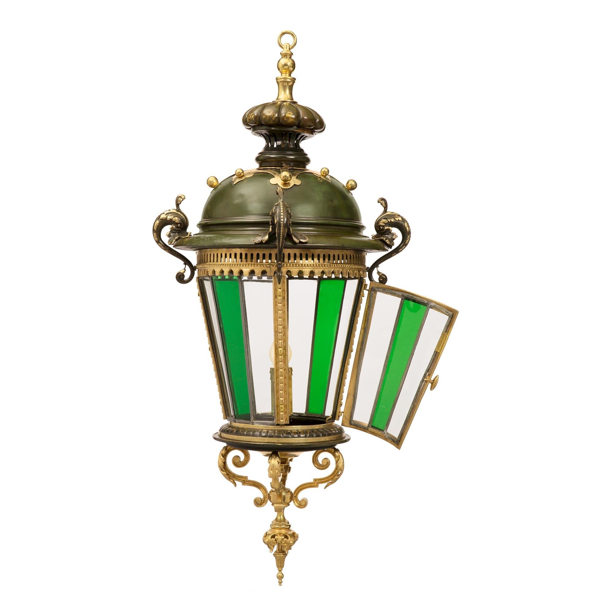 A unique and extremely decorative French mid 19th century Renaissance st. Verdigris patinated bronze, ormolu and glass lantern. The circular lantern is centered by a beautiful ormolu finial below striking scrolled movements adorned with large