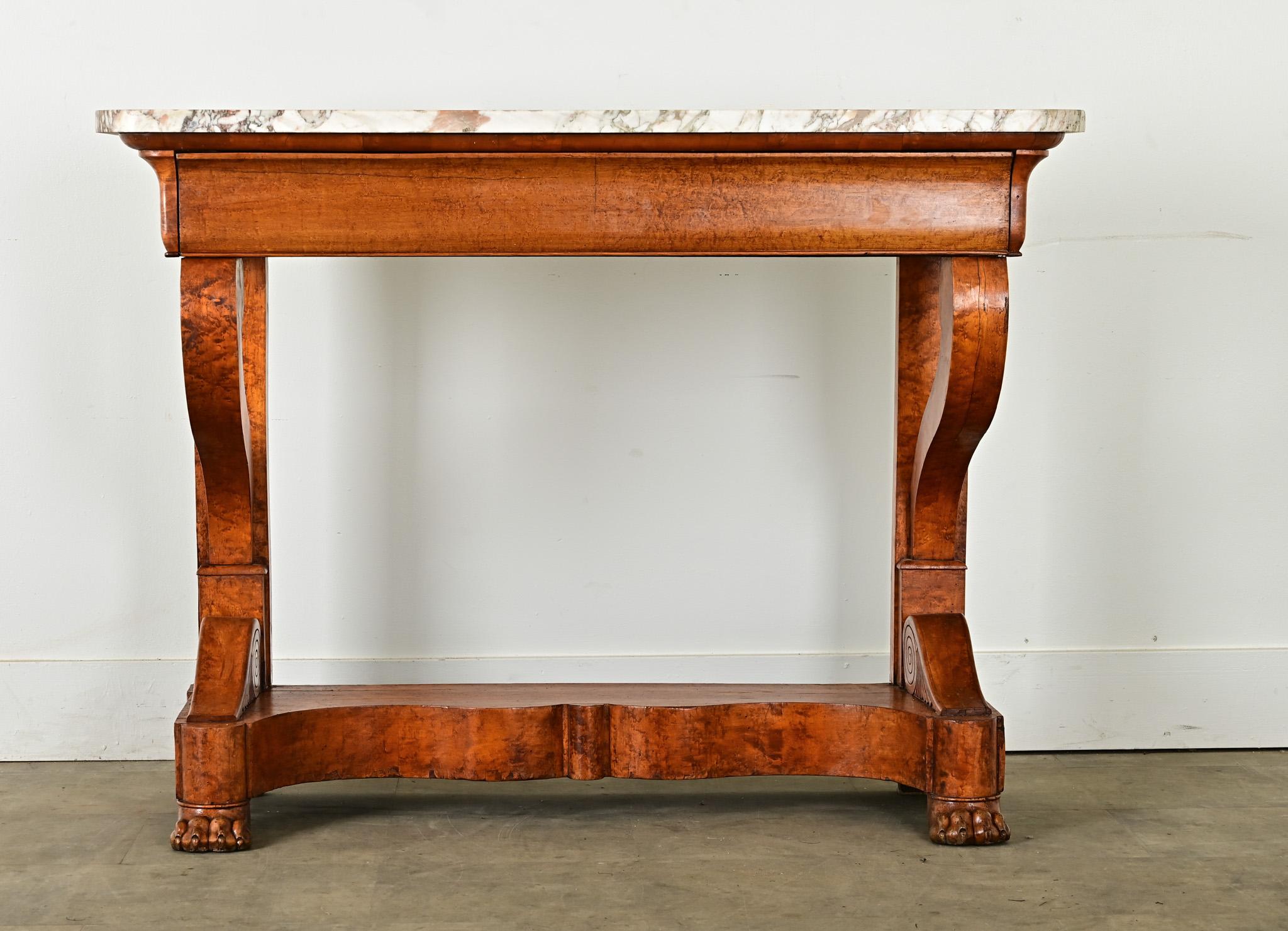 A handsome bird’s-eye maple console made in the Restauration style with a white marble top. The marble-top features patches and streams of veining with rounded front corners, and rests atop a large hidden drawer that also functions as the table’s