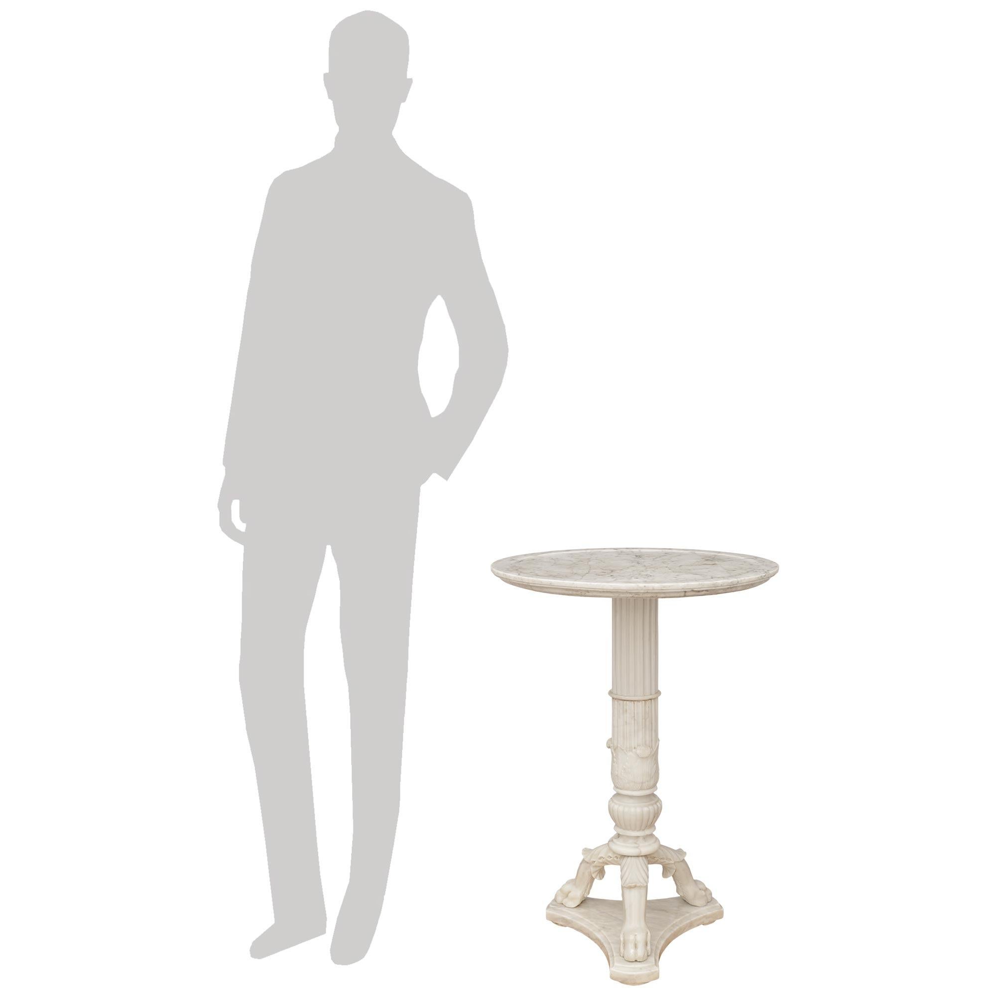 A high quality and most elegant French 19th century Restauration Period white Carrara marble side table. This stunning table is raised by a triangular shaped base with concave sides and a mottled edge, below three scrolled and pawed legs with top