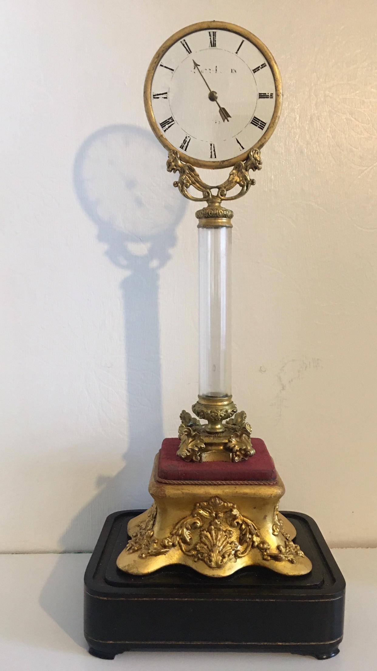 (Robert Houdin 1805-1870)
A very rare tall Houdin mystery clock from around the mid-19th century (circa 1850). A 4.75 inch glass dial raised on bronze with ormulu mounds on a giltwood base along with a signed movement.

The image also provides