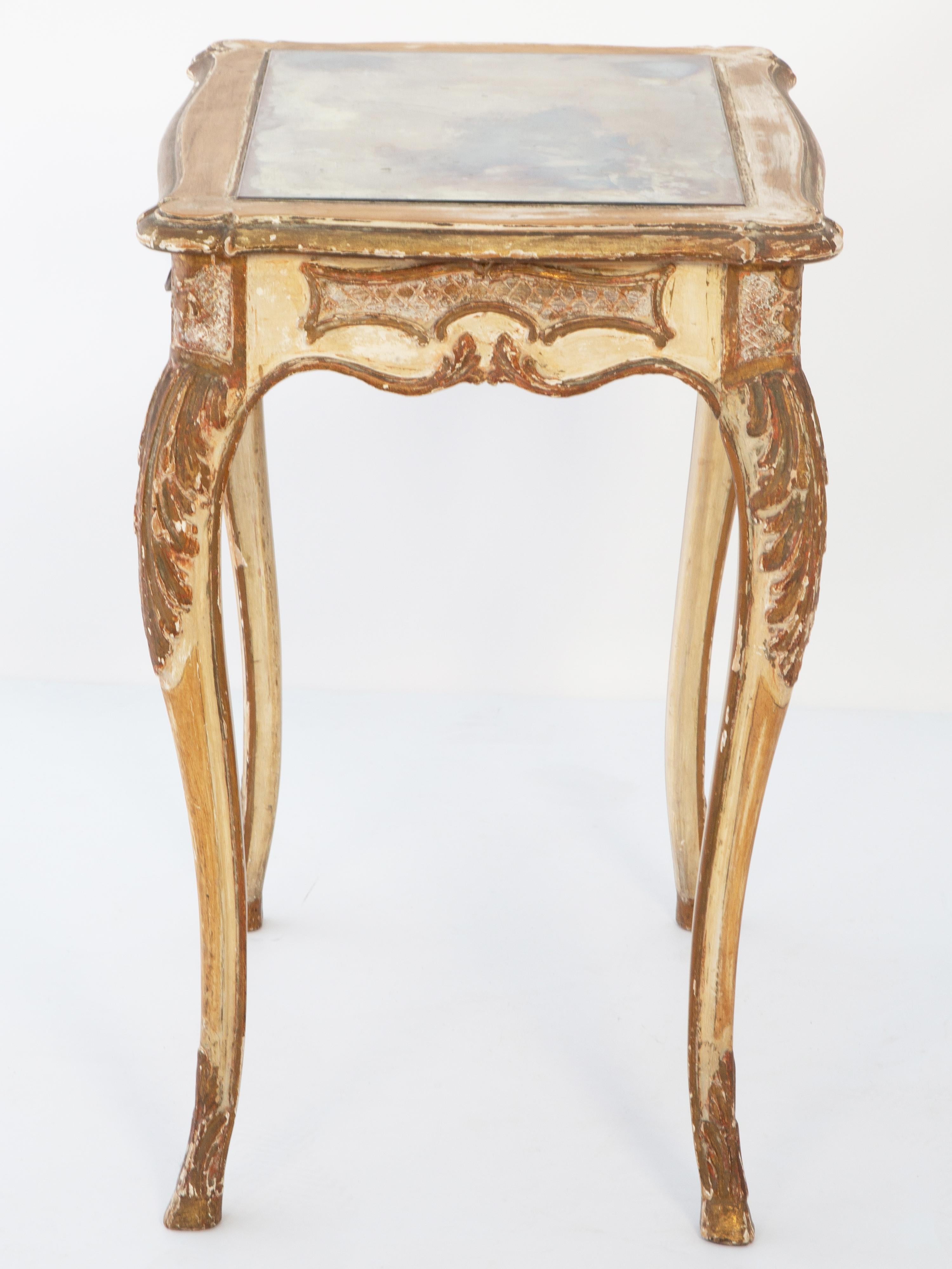 Ambulante d'époque de style rococo avec une finition peinte et dorée parcellaire montrant une usure souhaitable. Son plateau de forme inséré dans une plaque de miroir ancienne, surmontant un tablier serpentin avec des panneaux hachurés flanquant un