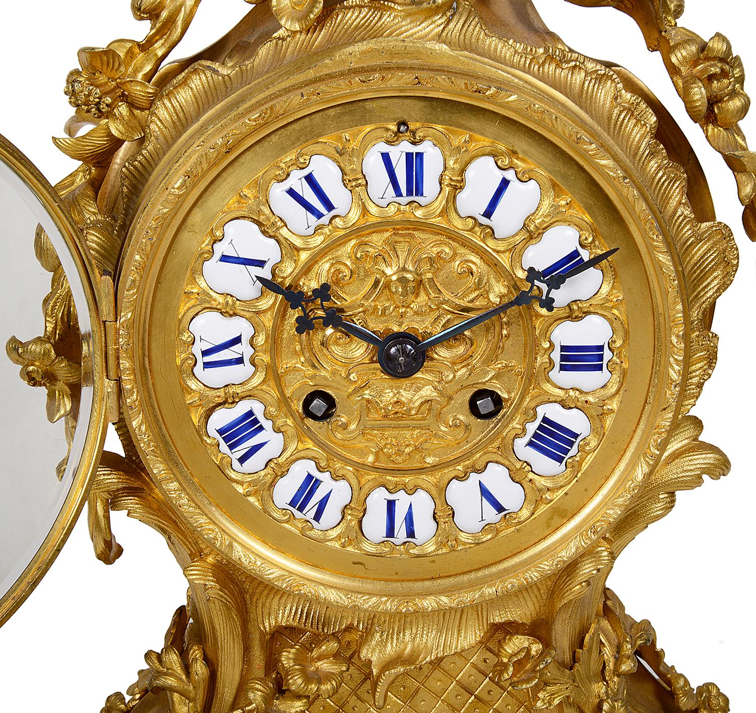 A very good quality 19th century French gilded ormolu Louis XVI style mantel clock, having wonderful scrolling foliate decoration in the Rococo style, garlands of flowers draped either side of the clock. White and blue enamel Roman numeral to the