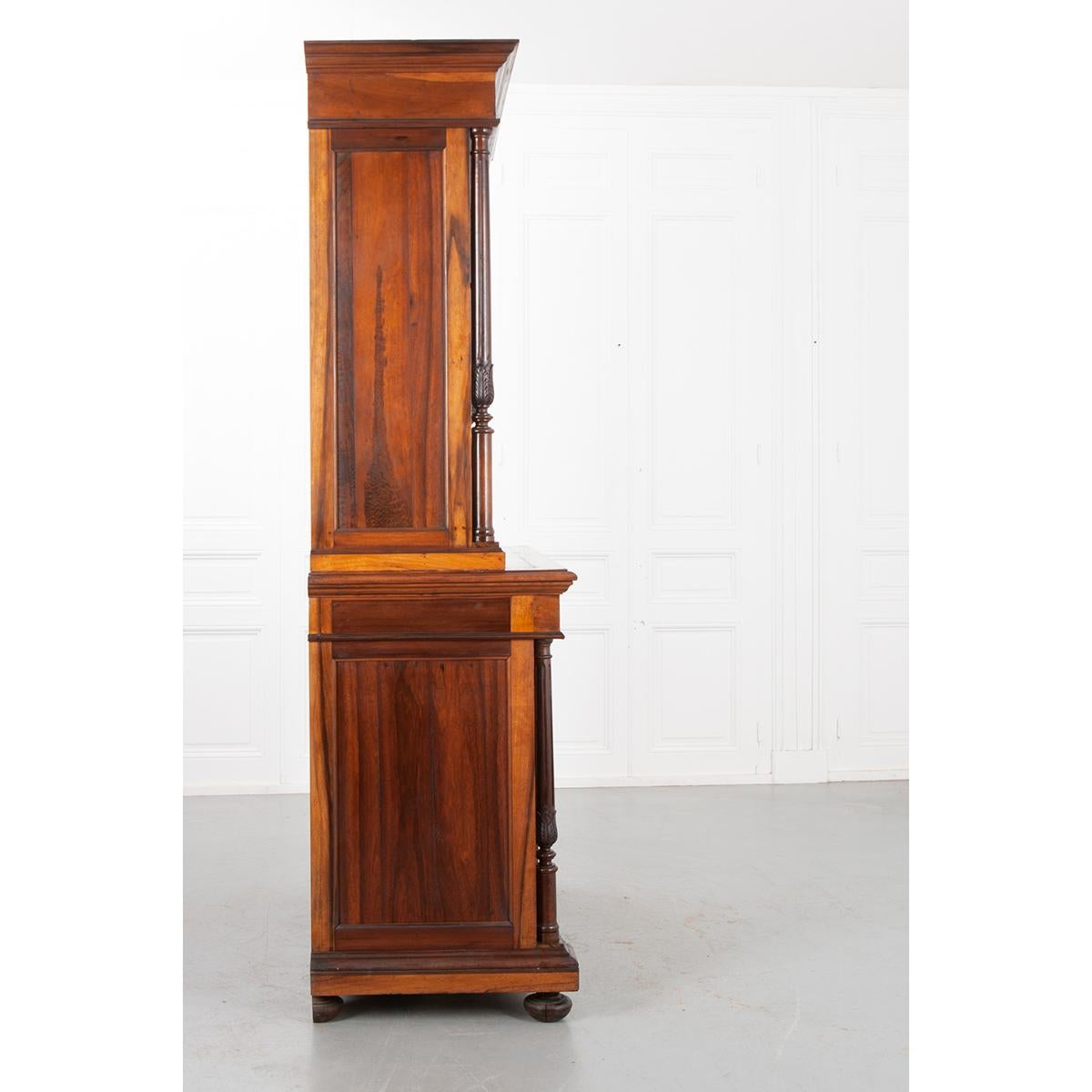 This beautiful French 19th century buffet a deux corps is made of solid rosewood. It has a wonderful patina and amazing natural wood design on the bottom doors. Fluted columns with carving are on either side of these doors. The bottom half of the