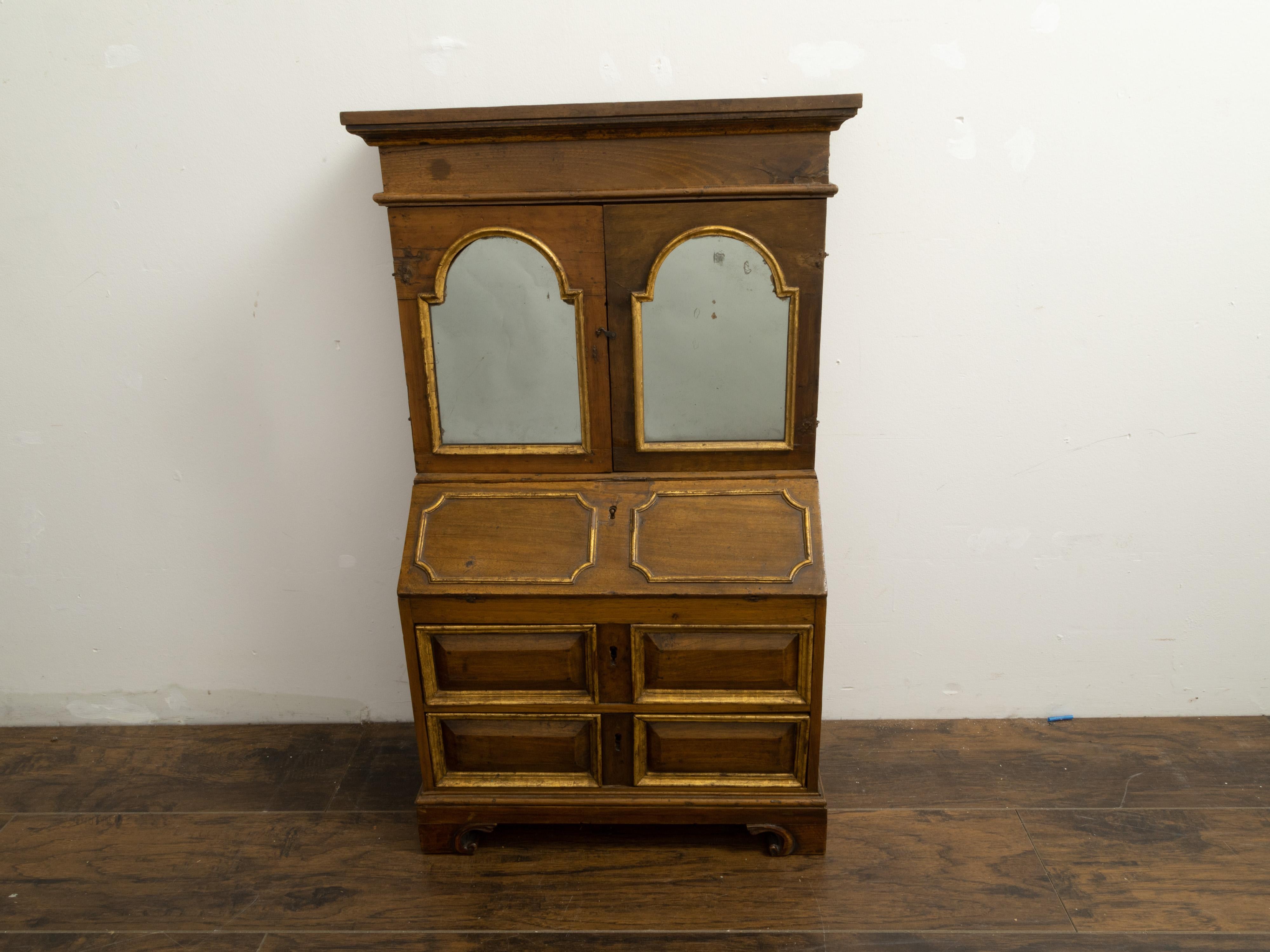 A French miniature slant front secretary from the 19th century, with arched mirrors and gilt accents. Created in France during the 19th century, this miniature slant front secretary features a molded cornice sitting above two doors adorned with