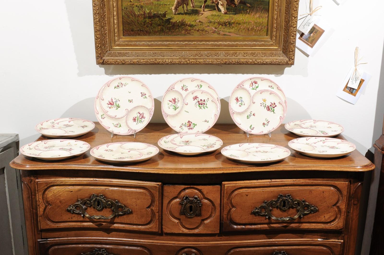 Ten French Sarreguemines Majolica asparagus plates from the 19th century with floral décor, priced and sold individually. Born in France during the 19th century, each of these delicate Sarreguemines asparagus plates features a lovely hand painted