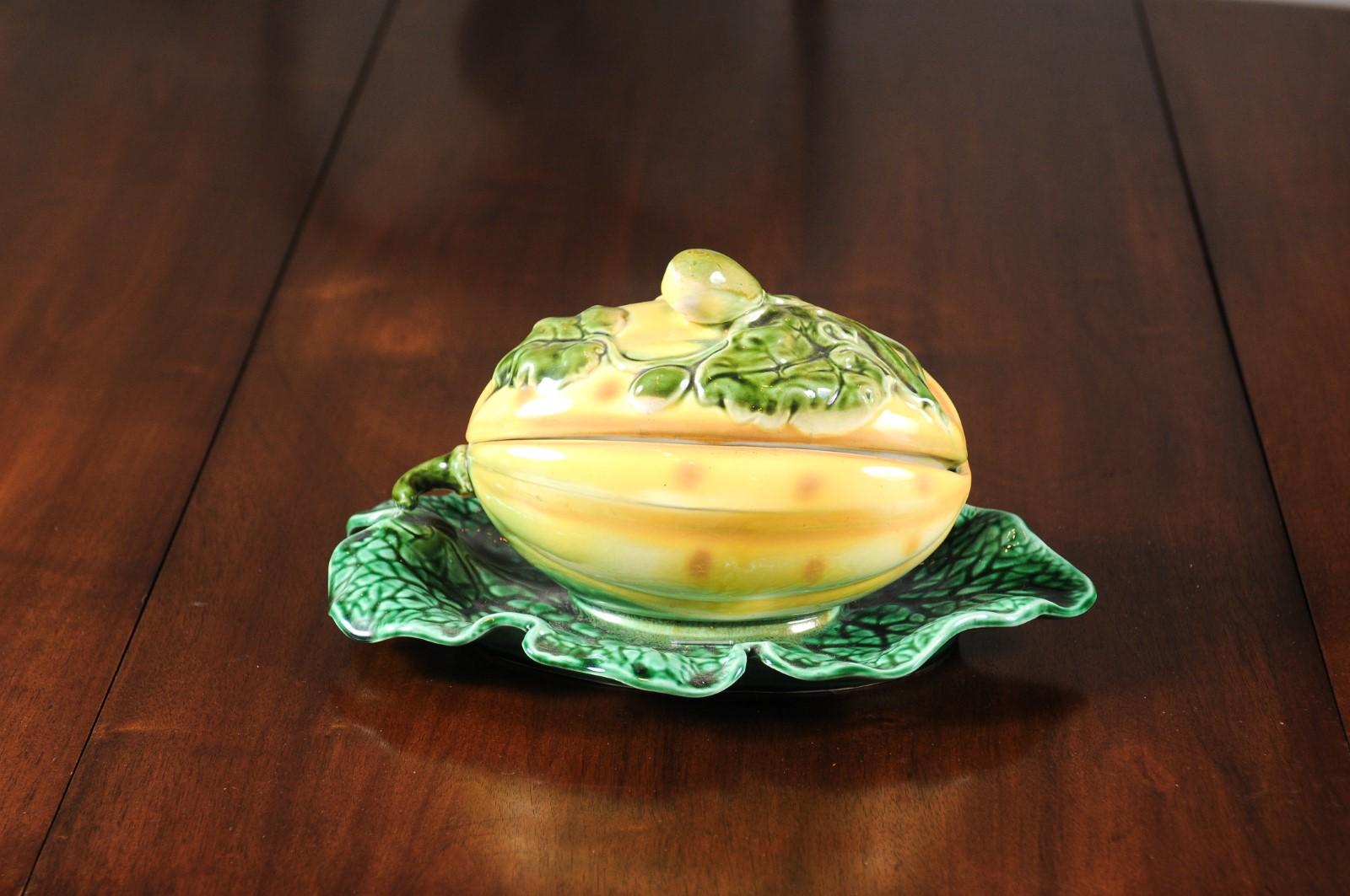 A French Sarreguemines Majolica squash-decorated lidded dish from the 19th century resting on a green leaf. Born in France during the 19th century, this Sarreguemines Majolica features a yellow and green glazed Majolica lidded dish, resting on a