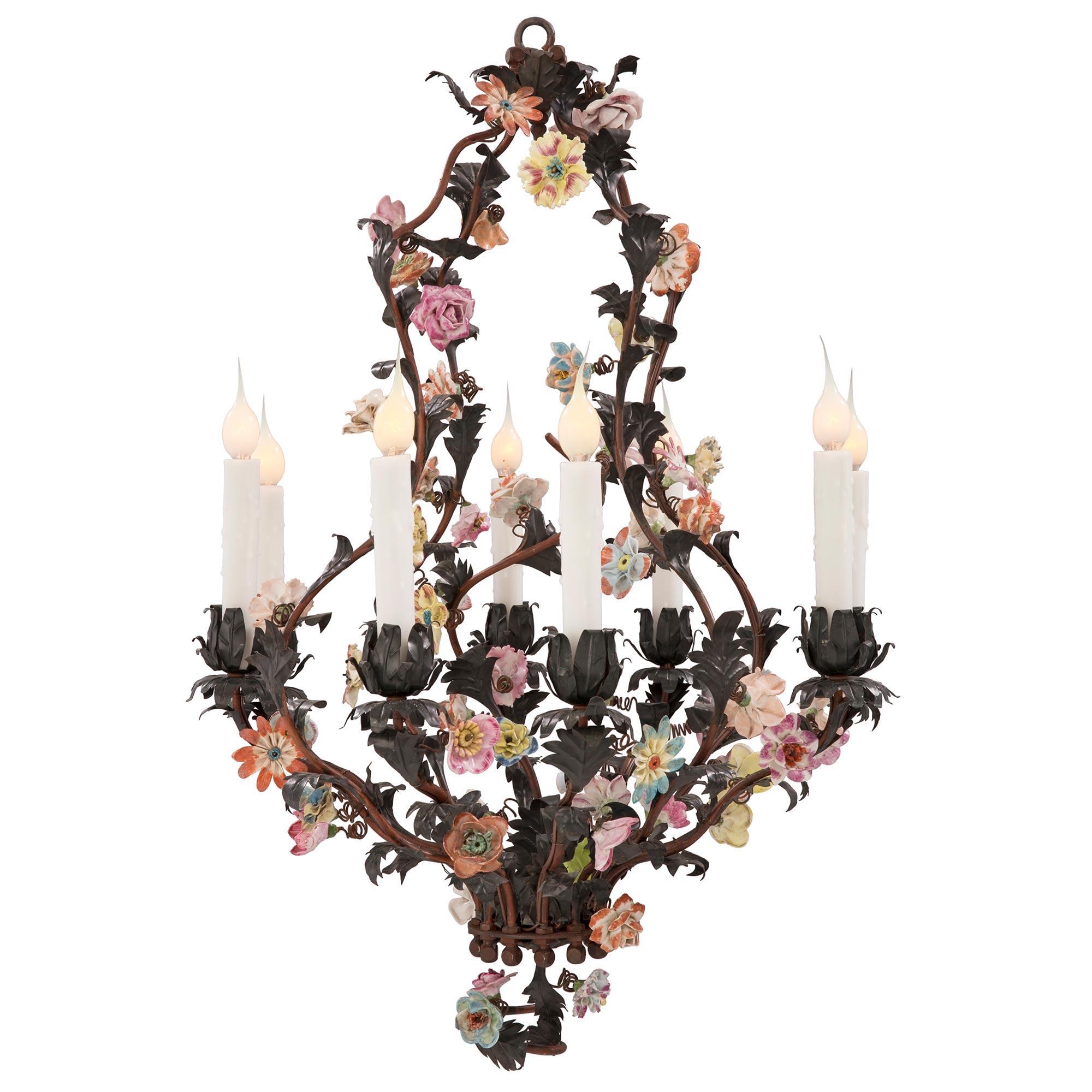 A lovely and most charming French 19th century Saxe porcelain, tole and patinated bronze chandelier. The eight light chandelier is centered by an elegant spiraled design with exquisite Saxe porcelain flowers. The patinated bronze cage displays an