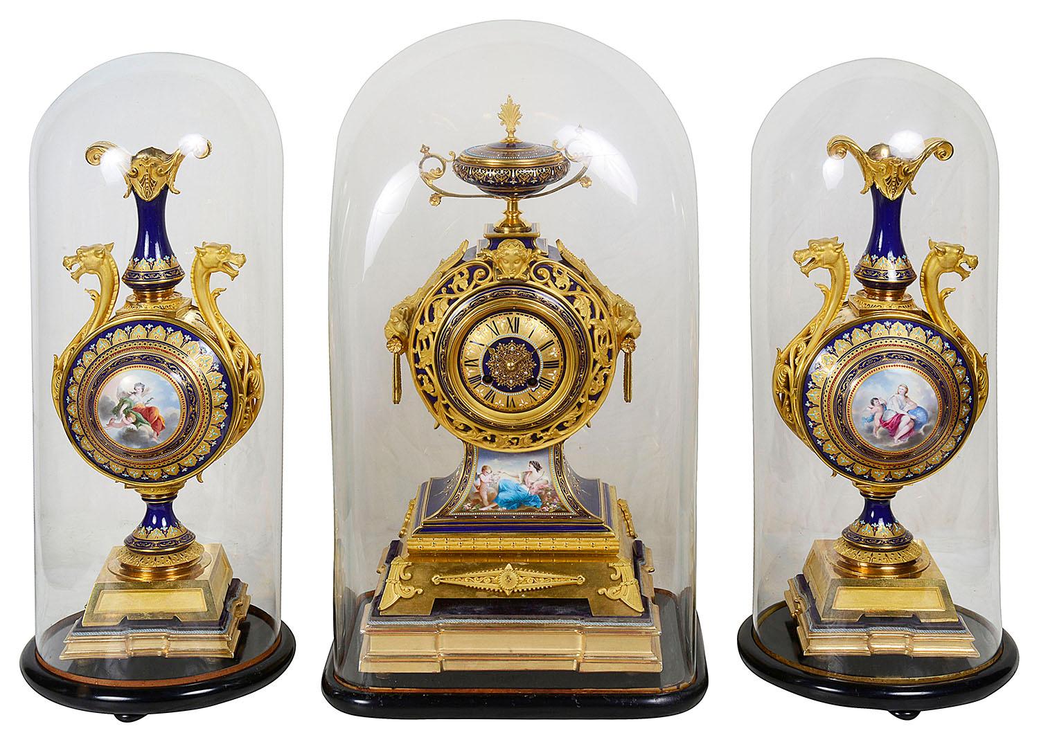 A very good quality 19th century French gilded ormolu and Sevres style porcelain clock set. Having glass domes to all three pieces. The clock has an ormolu urn to the top, the cobalt blue porcelain with gilded motif decoration. The porcelain face