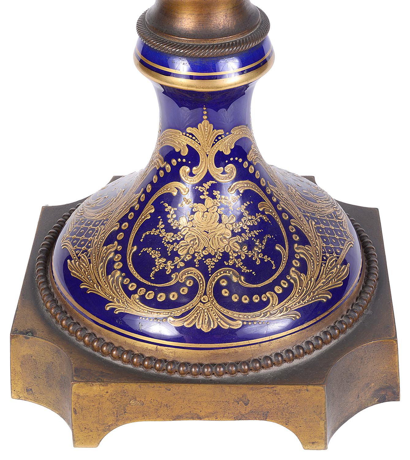 A good quality 19th Century French Sevres porcelain lidded vase, having gilded ormolu finial and handles, cobalt blue ground with gilded scrolling decoration. The central painted panel depicting a romantic scene to the front and children playing to