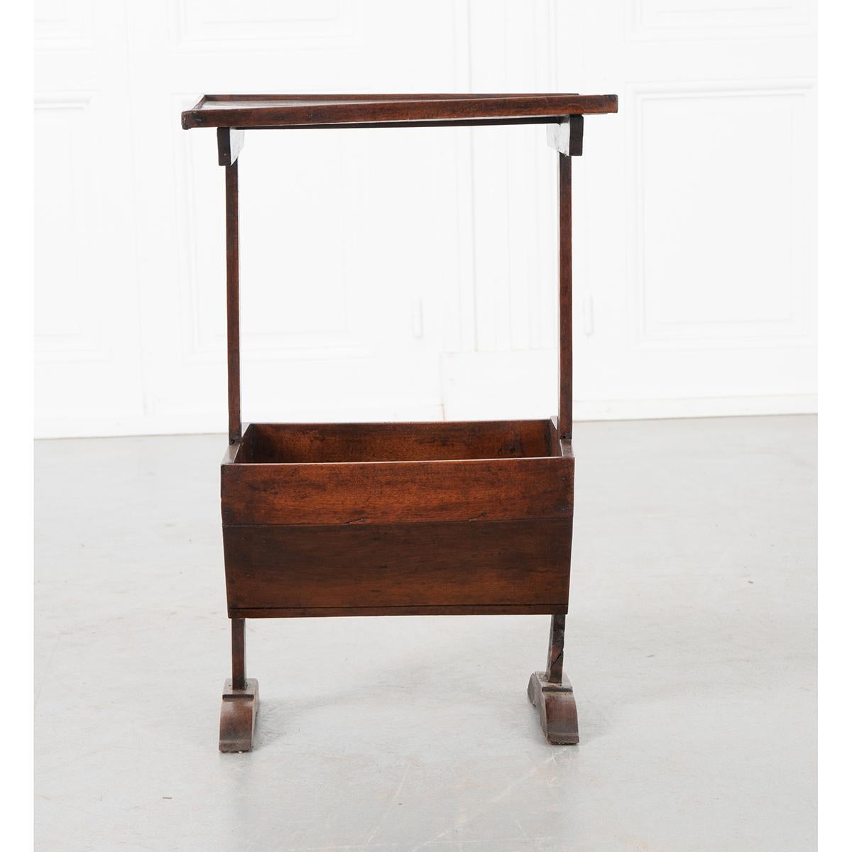 This simple little walnut table from 19th century France is actually a functional sewing table. It has a flat work surface with a basket below to hold knitting or any sewing project that the owner was working on. A very handy table to have around
