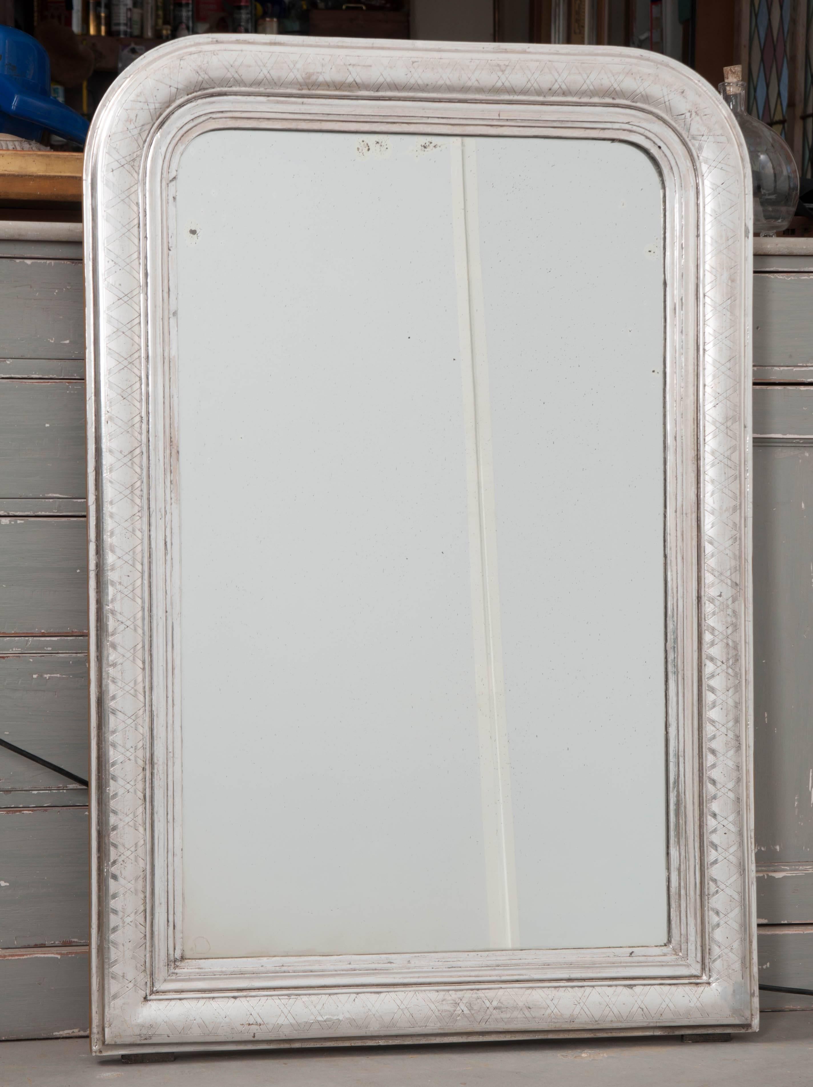 A brilliant silver gilt Louis Philippe mirror from 19th century France. The frame is smaller in size, making the mirror an ideal bathroom mirror. The silver gilt is in excellent antique condition, with an incredible metallic lustre and nearly