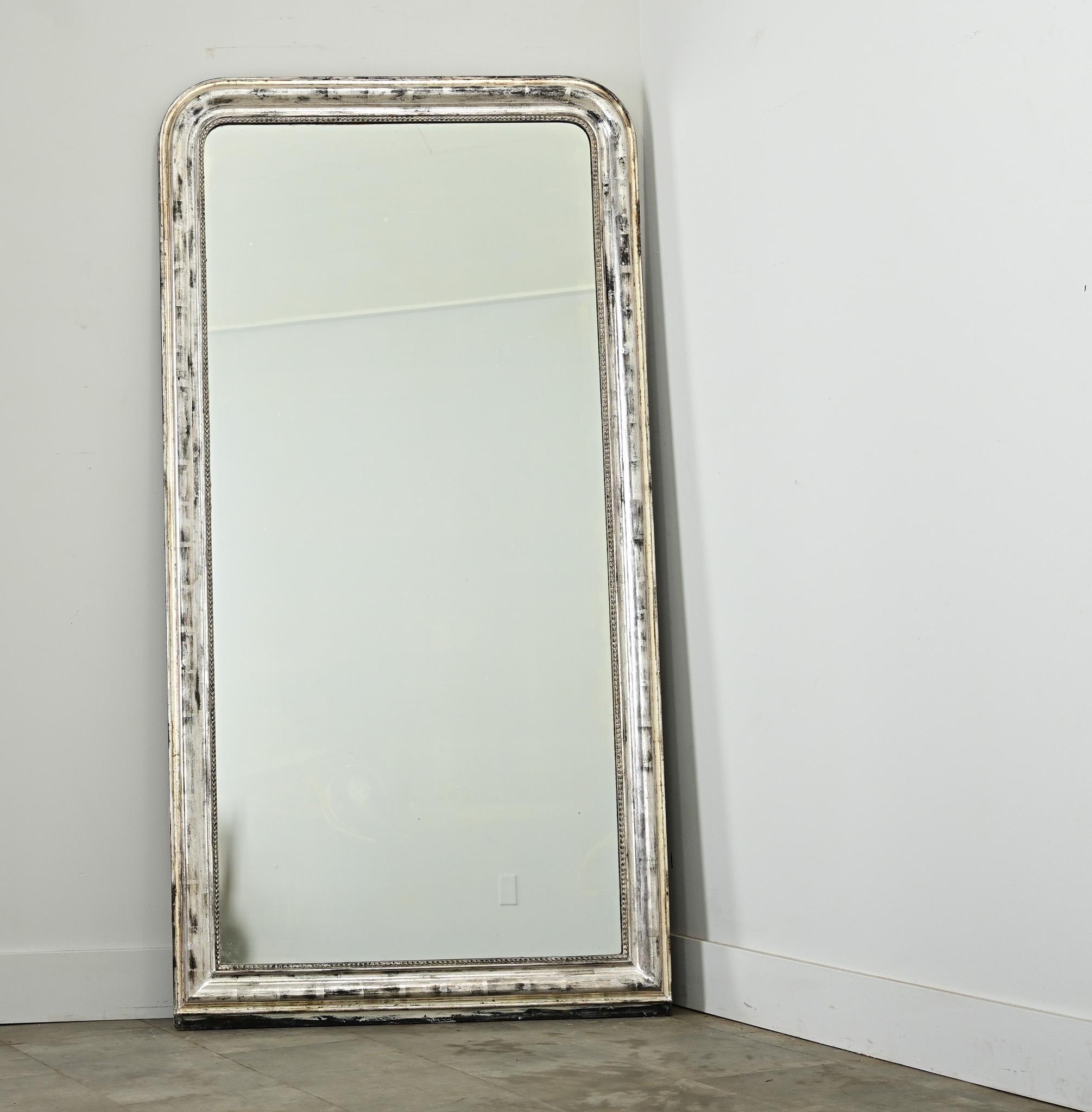 Specchio francese Louis Philippe del XIX secolo con cornice alta e dorata in argento, impreziosita da ossidazione scura e craquelure che conferiscono una patina autentica al design (architettonico). La lastra originale dello specchio è delineata da
