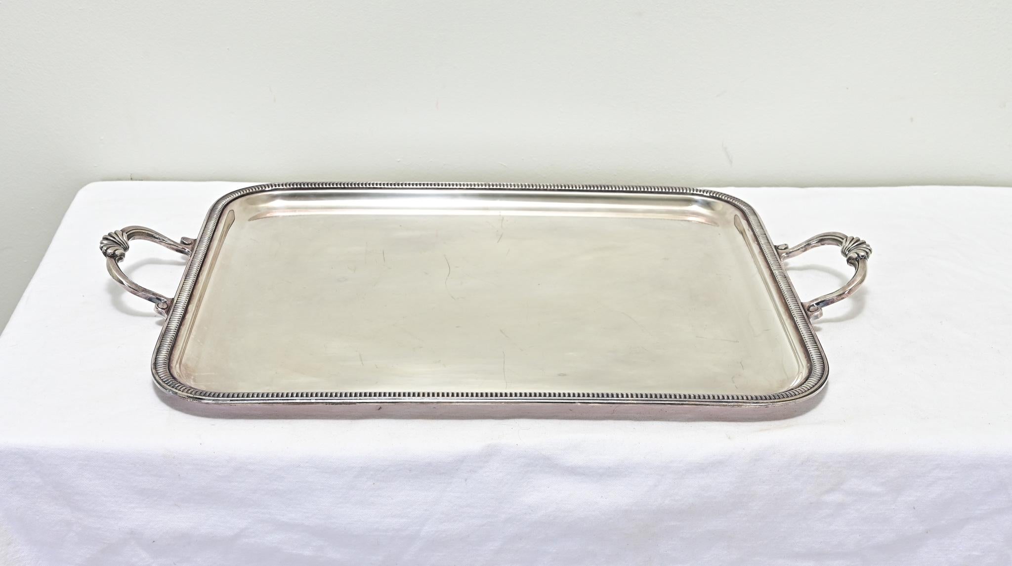 This quality silver plate rectangular tray from France is perfect for serving or for decoration. The simple flat interior is framed with a beaded trim with laurel leaves on its handles. View all the detailed images for a closer look.