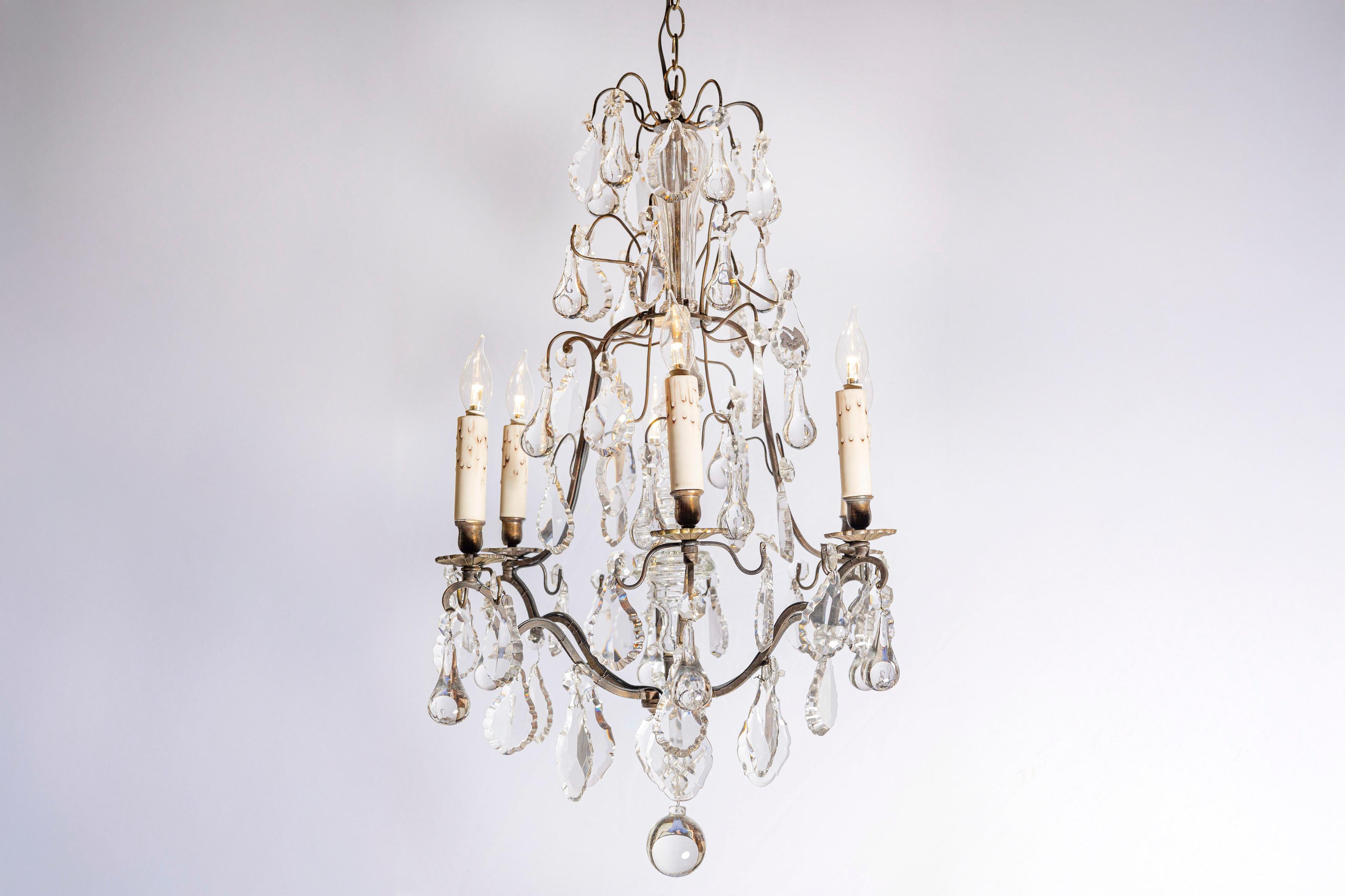 Lampadario francese a sei luci in cristallo del XIX secolo, con struttura in ottone patinato, pendeloques e gocce a goccia. Creato in Francia nel XIX secolo, questo lampadario di cristallo è caratterizzato da un'armatura in ottone invecchiato e