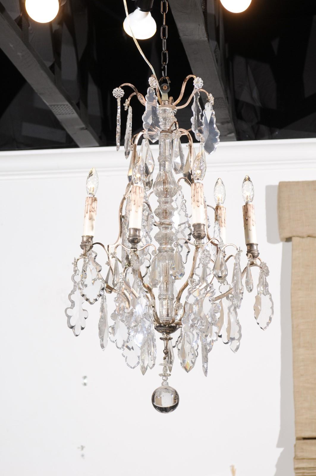 A French six-light crystal silvered chandelier from the 19th century with central column, pendeloques and lower finial. Born in France during the 19th century, this exquisite crystal chandelier features a central crystal column connected to a