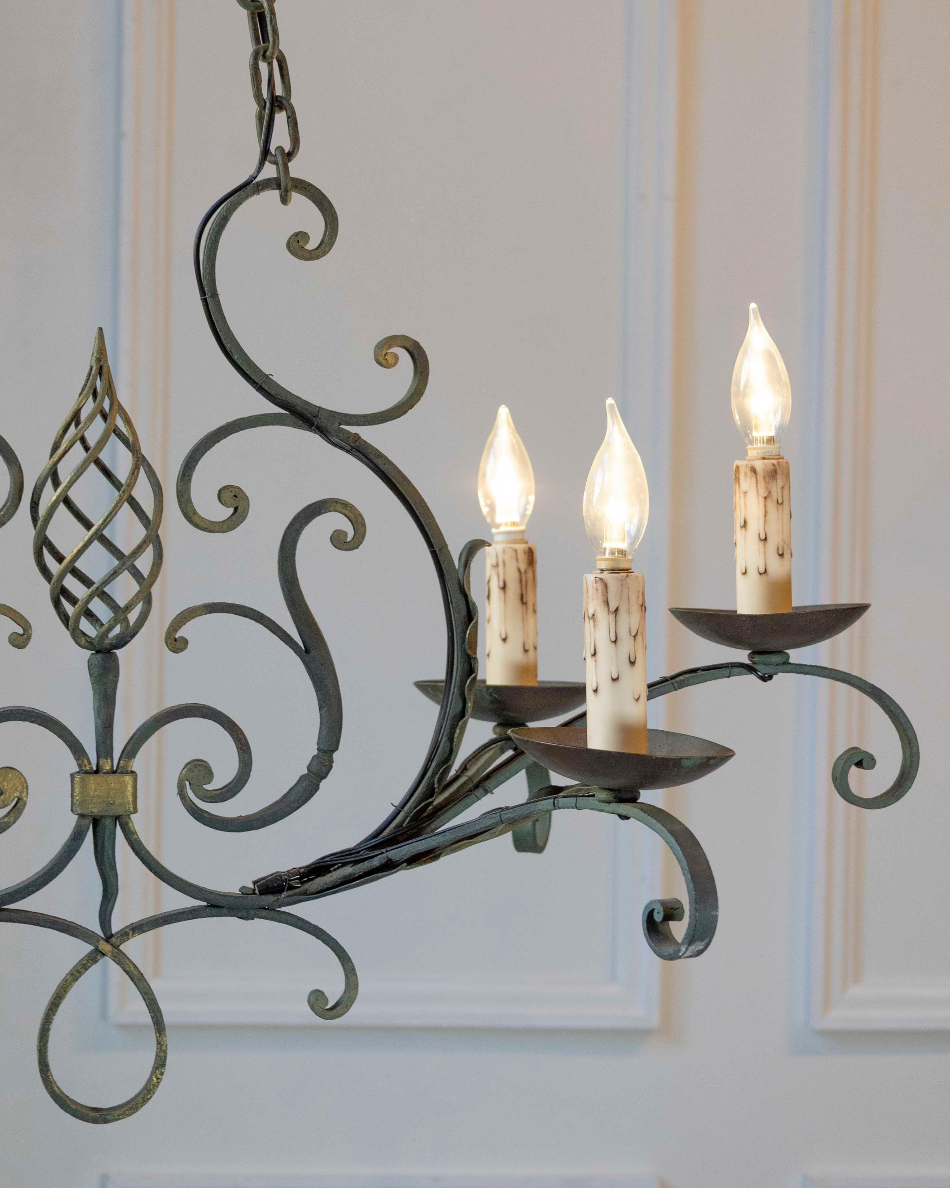 A French six-light iron chandelier from the 19th century, with spiral motif, gilt accents and scrolling arms. Created in France during the 19th century, this six-light chandelier features an iron armature presenting profiled links connected to two