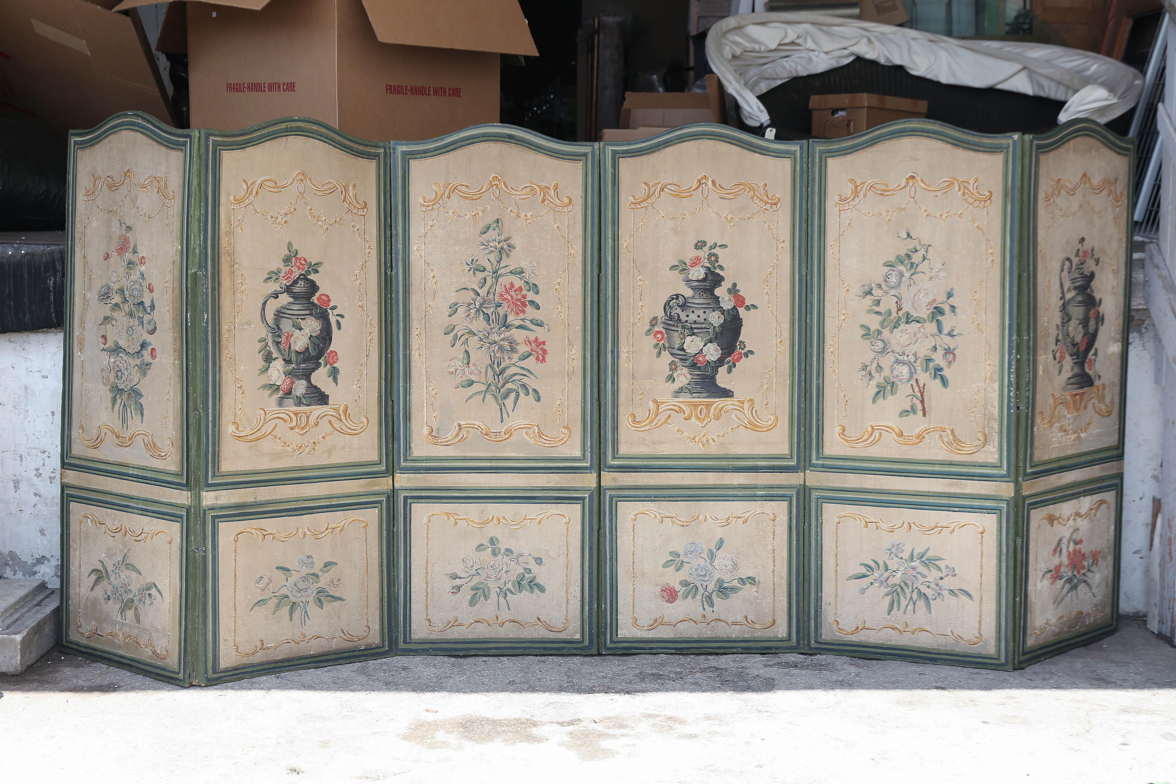 French 19th century painted canvas screen features alternating vase and floral decorations in a very pale palette.

Each panel is framed and painted a blue-green.

Back of screen is painted in monochromatic tones of blue.

