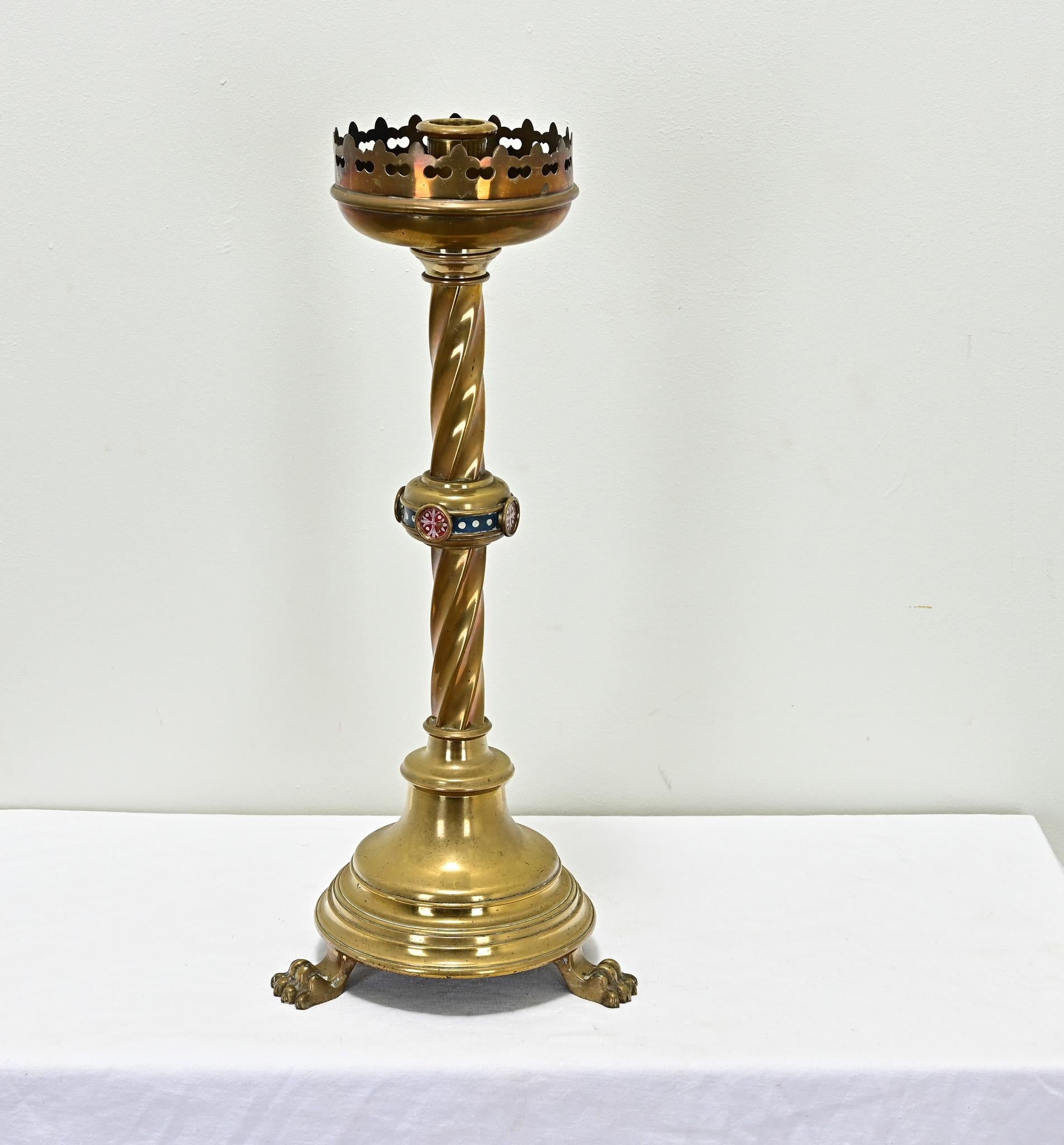 Un grande candeliere francese in ottone massiccio proviene probabilmente da un altare della chiesa. Questo candeliere pesante e di qualità presenta una corona traforata in alto su una colonna ritorta con medaglioni Champlevé. La base è sollevata su