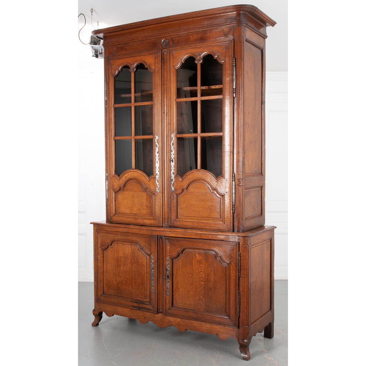 This is a massive Buffet a Deux Corps from 19th century France. Constructed with warm solid oak, the top portion measures 68”H x 54-⅜”W x 21-¼”D and the bottom measures 38-⅓”H x 63-¼”W x 24”D. Topped with a protruding rounded cornice and a lovely
