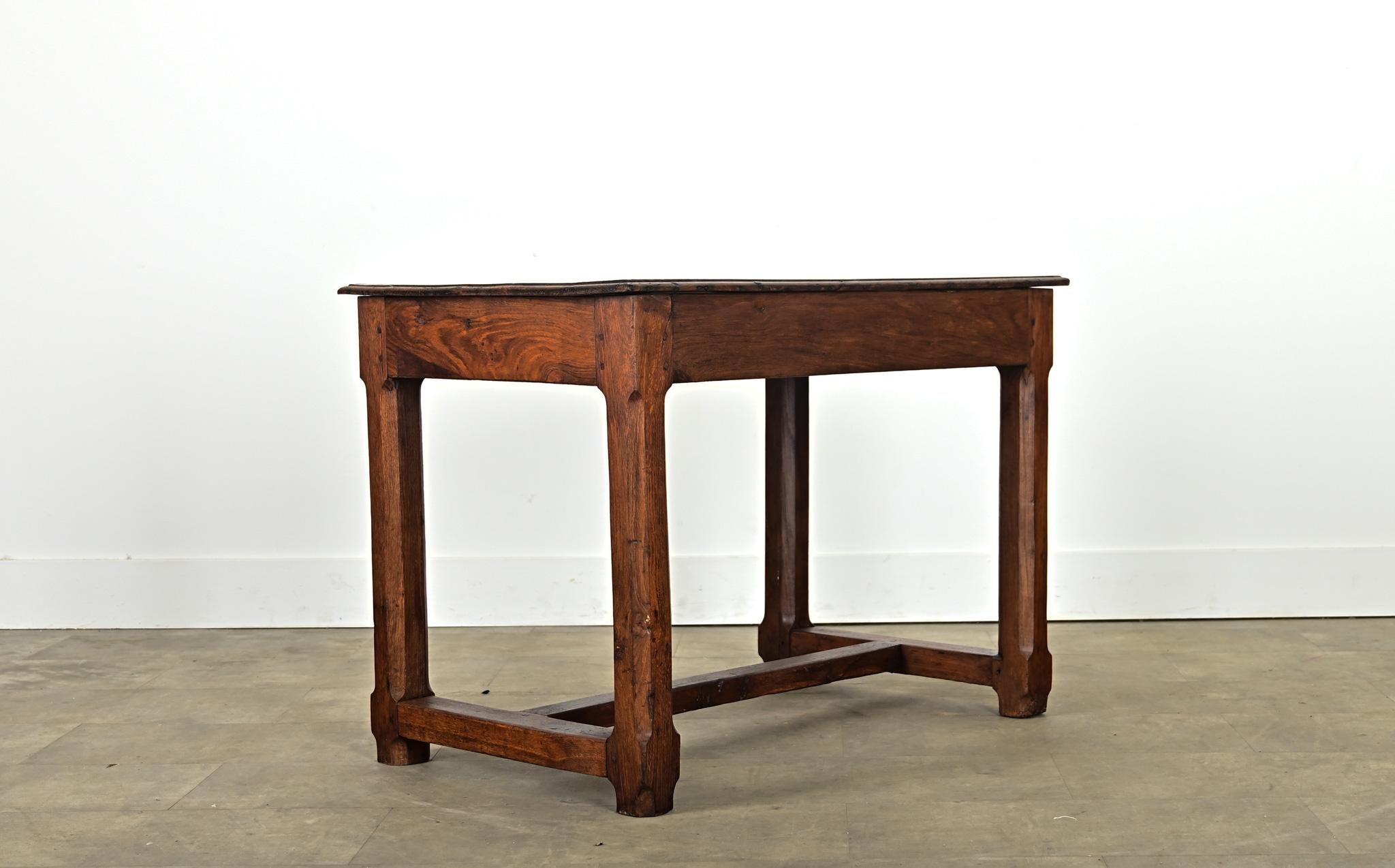A petite oak farm-style table from 19th century France, appearing to be a substantial console table that easily doubles as an occasional serving table, center table, or possibly a desk. The heavy, solid oak construction was entirely handmade using