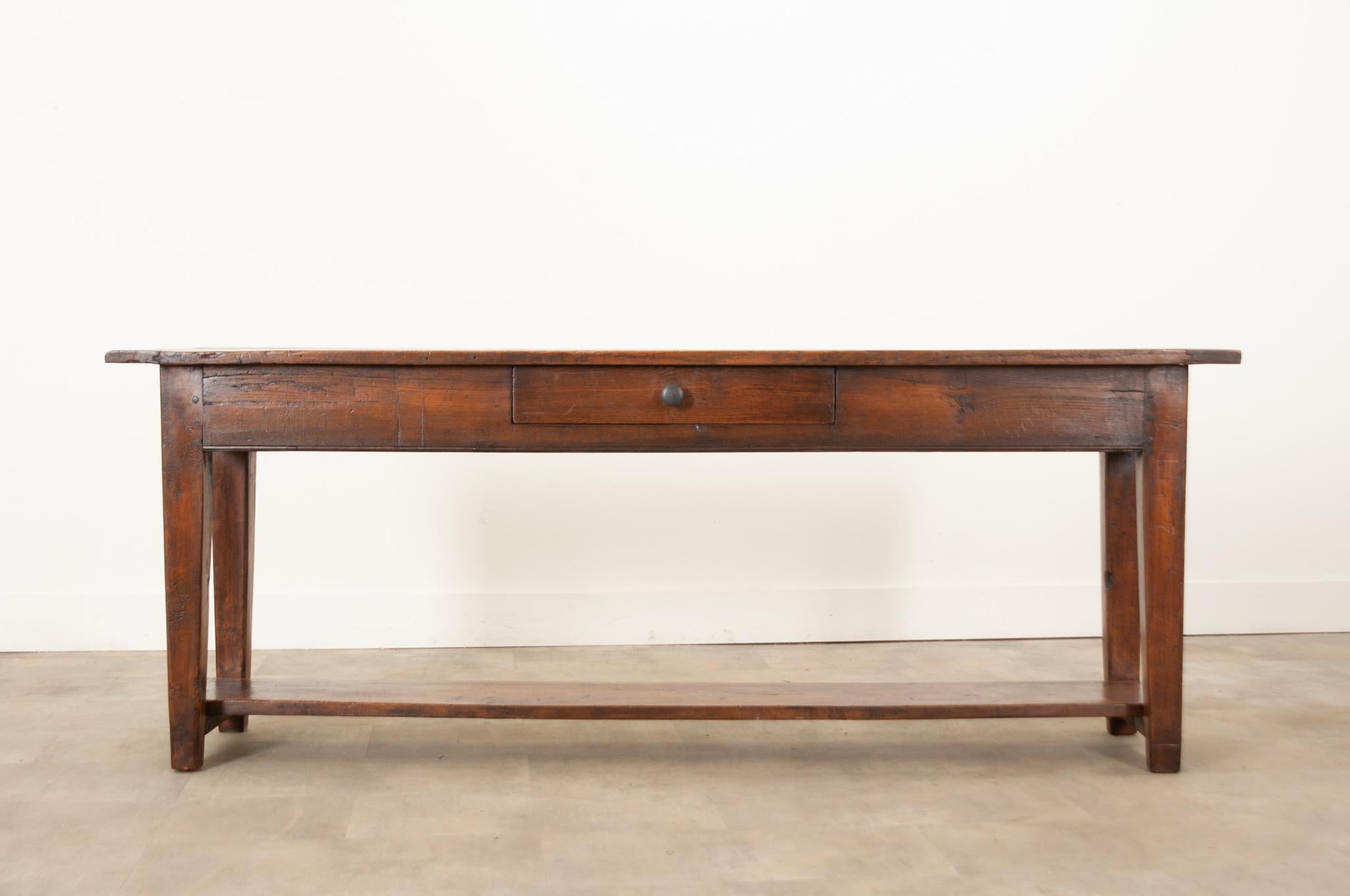 A handsome solid oak server handcrafted in France, circa 1850. This console table was made using peg joinery, which accounts for its sturdiness and robust stability. It has a sleek apron which houses a single, wide drawer, accessed by a simply