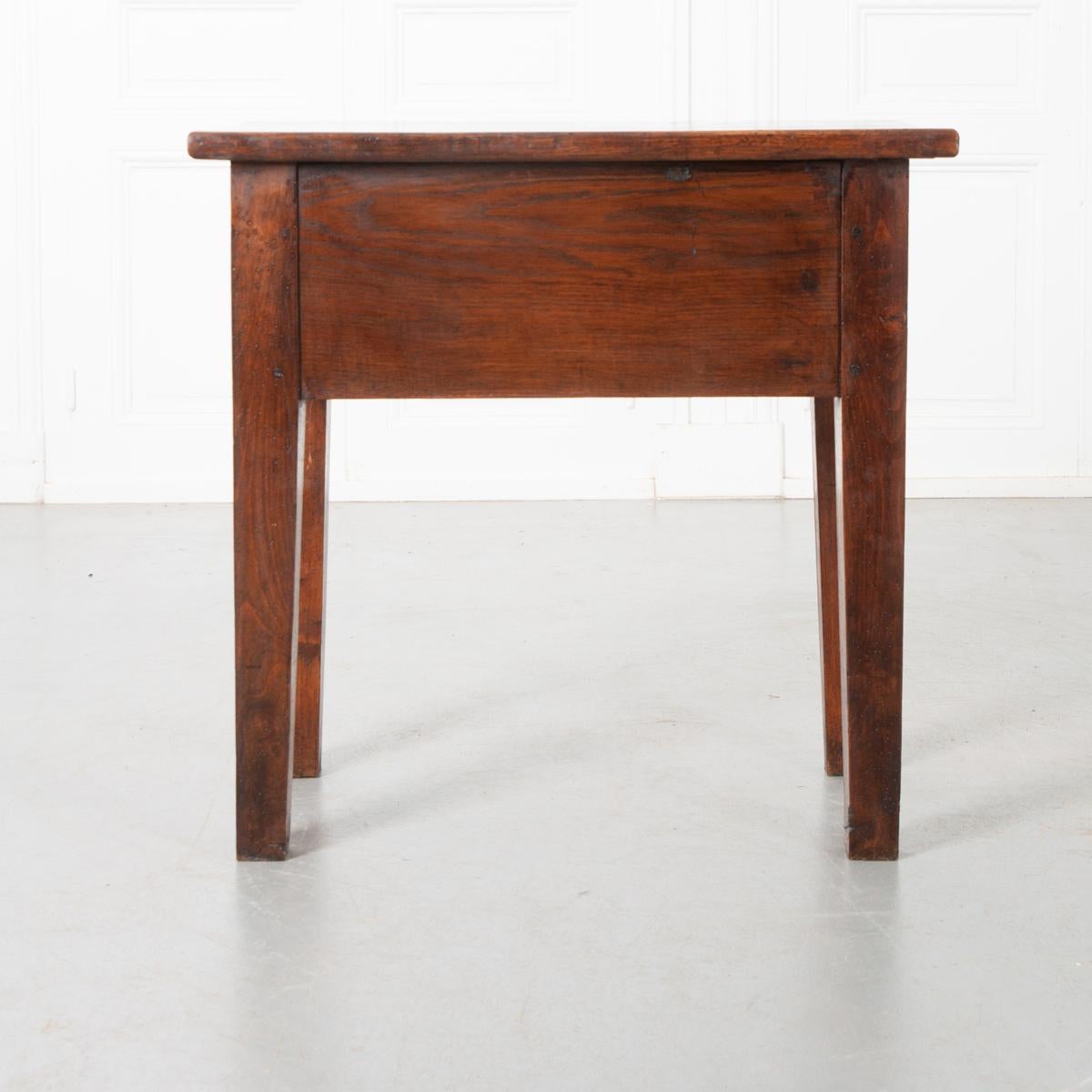 The French 19th century solid oak table has one deep drawer with a metal round knob. The legs are square and tapered. Simple and sophisticated, this little table can go in many places in your home.