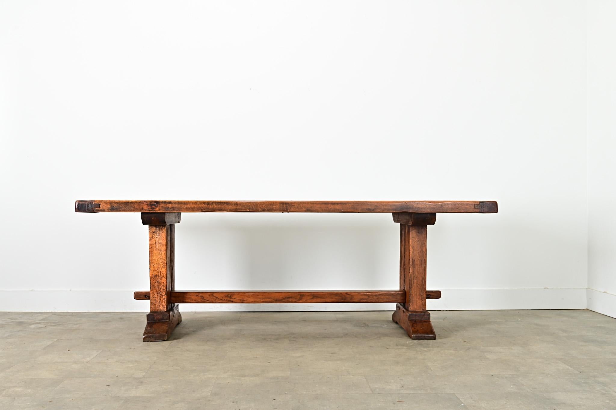 
A monumental 19th century French oak dining table with unique, architectural elements in the trestle base. Impossibly heavy, the top planks are nearly 3” thick, old-growth wood including dense grain patterns and knots, all assembled with square peg
