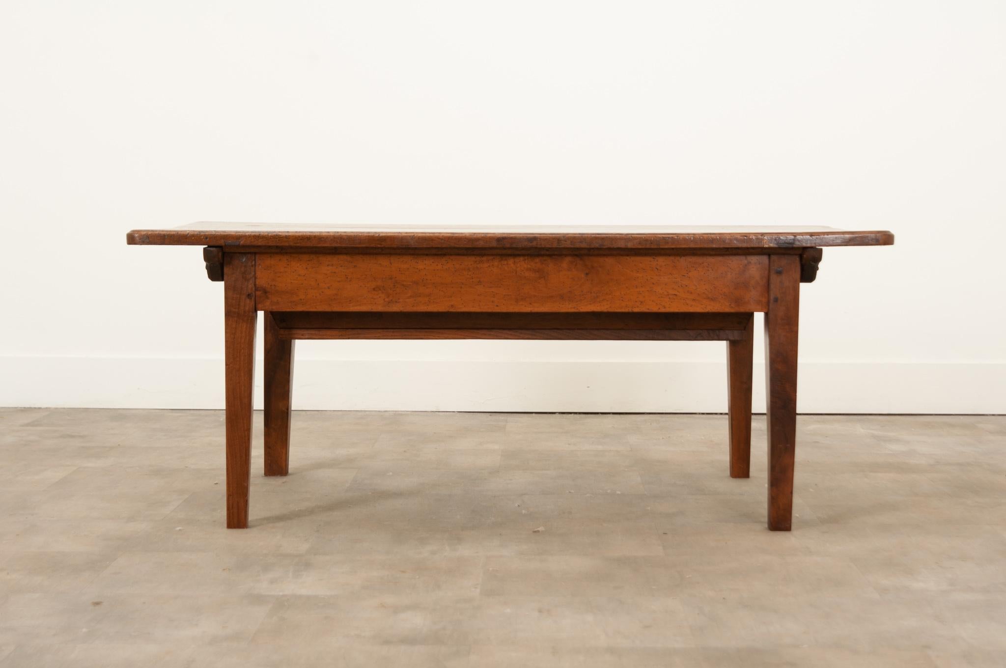 A rare French 19th century antique hand-crafted in France circa 1850. A hardy solid walnut petrin coffee table with removable top and dough bin base on square tapered legs. This kneading table features a rectangular removable top of solid planks