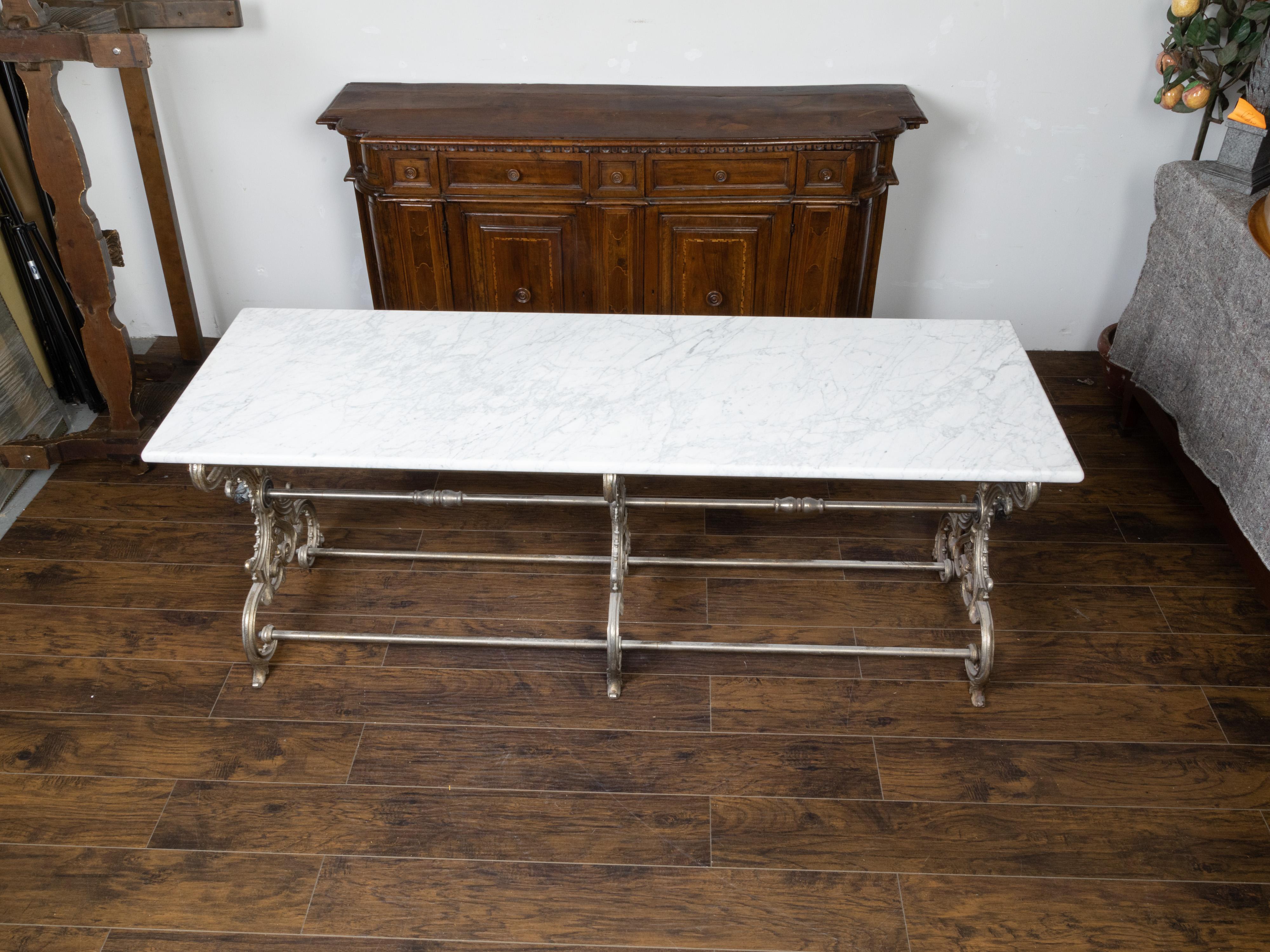 A French marble top butcher's table from the 19th century, with steel scrolling base and bulls' head motifs. Created in France during the 19th century, this table features a rectangular white marble top sitting above an elegant base showcasing three