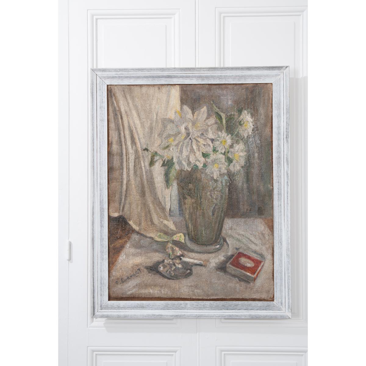 A softer palette, antique oil painting from 19th century, France. The work exhibits a vase holding dahlias and daisies, a cigarette and matches. The piece is set in a white and gray frame that works nicely with the painting. The artist has marked