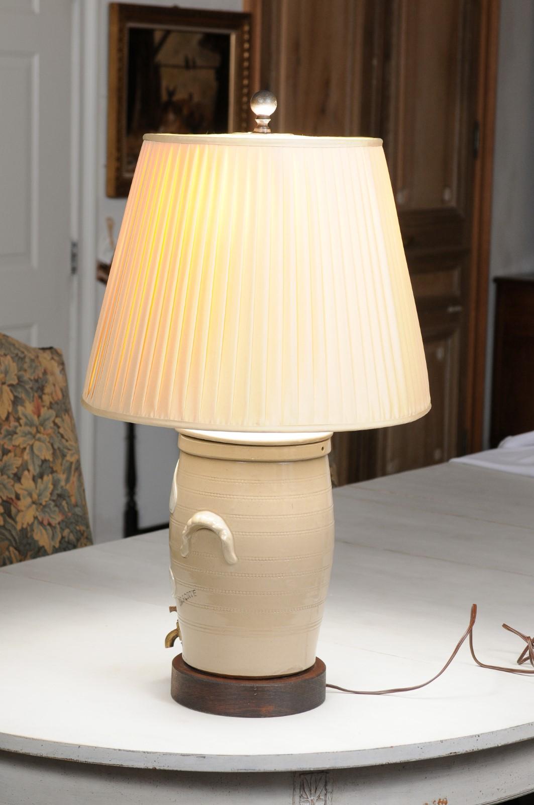 A French stoneware spirit barrel from the 19th century made into a table lamp with shade, mounted on a circular wooden base. Created in France during the 19th century, this spirit barrel was produced by a British company located on the Rue de Rivoli