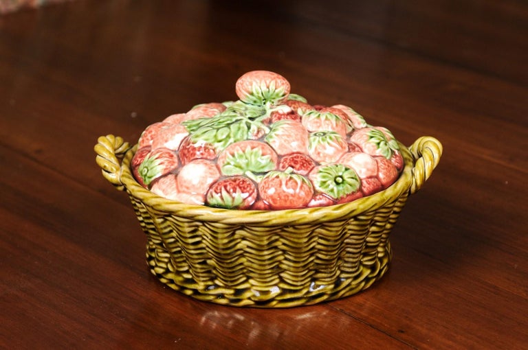 A French strawberry and wicker basket pottery dish from the 19th century with lid. Born in France during the 19th century, this charming dish features a wicker basket style base with lateral handles, overflowing with mouth-watering strawberries