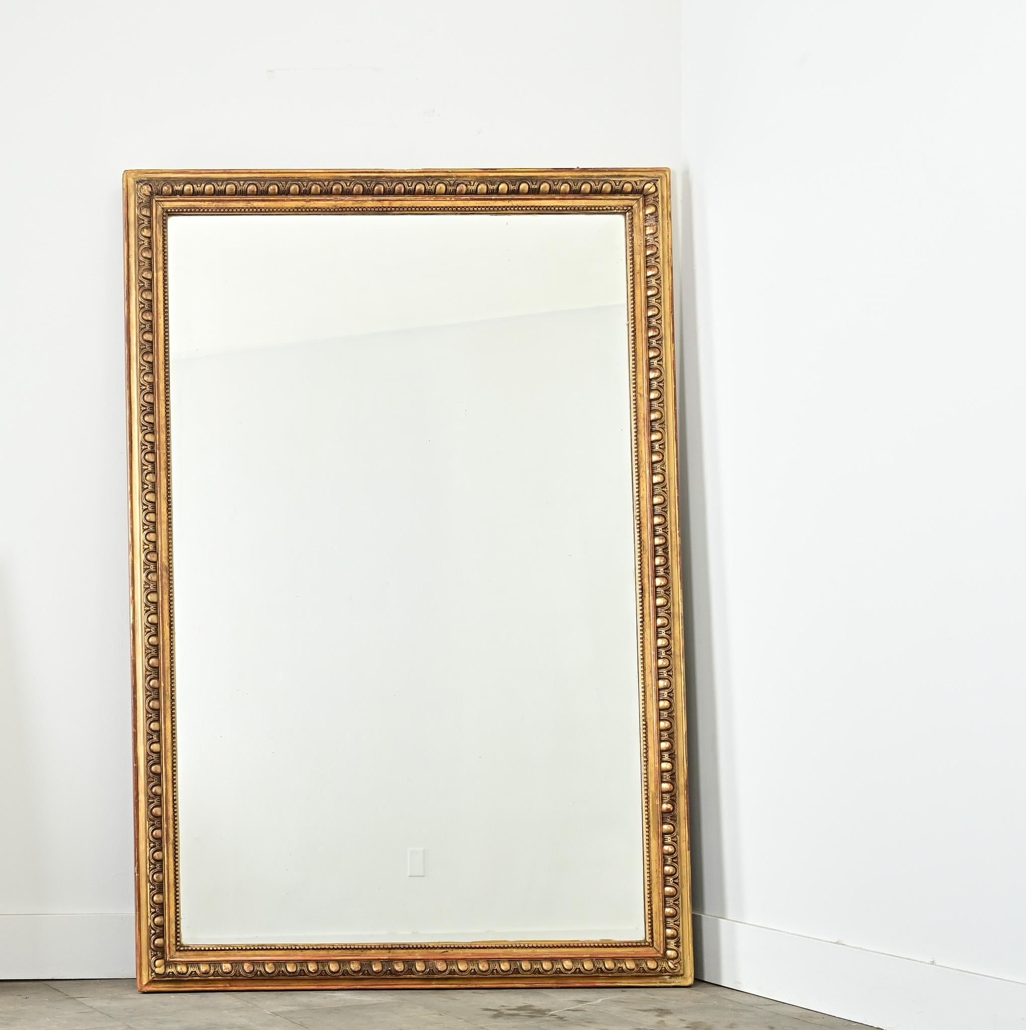 A stunning 19th century French gold gilt mirror of thick egg & dart molding around the original glass. The frame is of impressive scale, with bold definition between the smoothness of the protruding eggs and the linear patterns outlining them,
