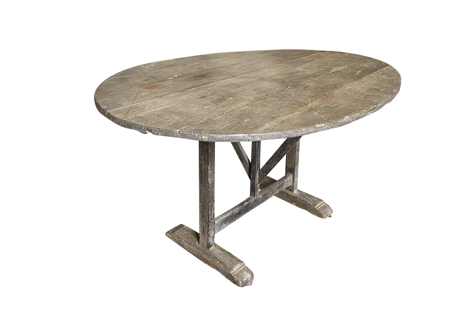 A very beautiful later 19th century oval shaped table Vigneron - Wine tasting table from the Provence region of France. Soundly constructed from naturally washed oak with the top that tilts. Terrific for interior or exterior use.