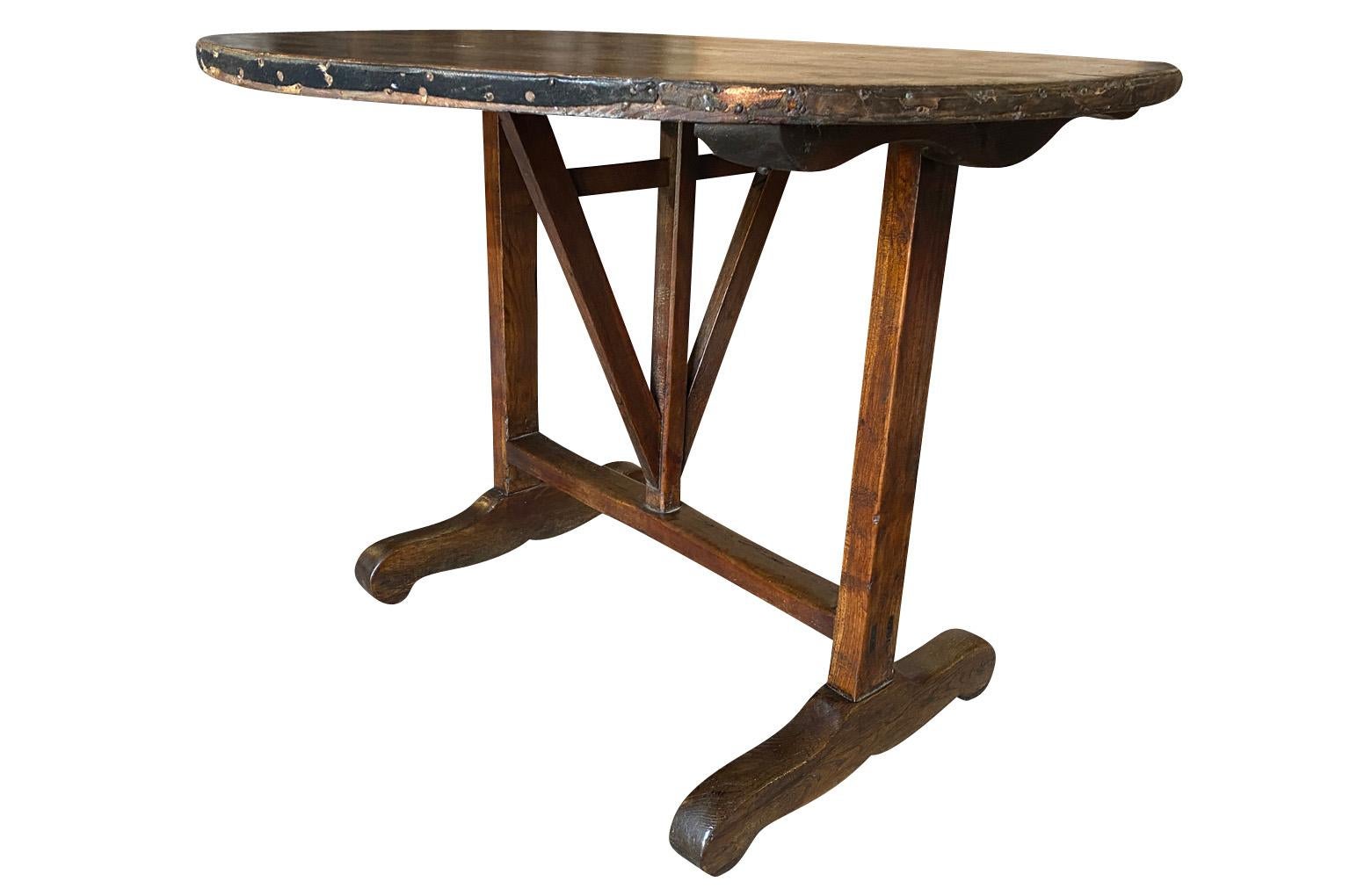 A very charming mid-19th century Table Vigneron - Wine Tasting Table from Beaune, France.  Beautifully constructed from richly stained oak with a tilting top, charming scalloped braces under the top and a handsome moleskin top.  Fabulous patina.