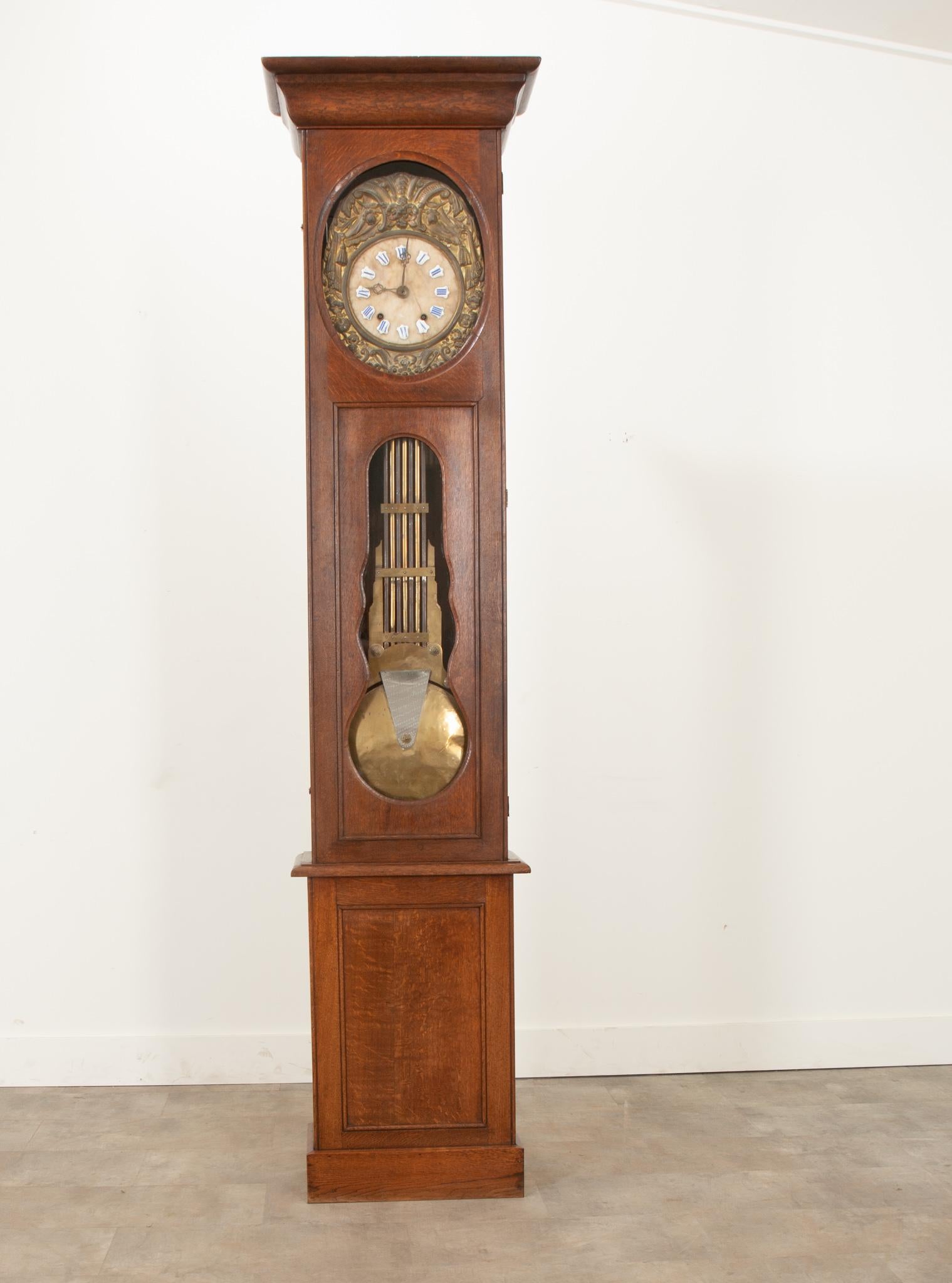 Diese fantastische Uhr mit massivem Eichengehäuse wurde im 19. Jahrhundert in Frankreich hergestellt. Eine scharf geschnitzte Haube über einer einzigen Tür mit Glasscheiben, durch die das Zifferblatt und das Pendel zu sehen sind. Das