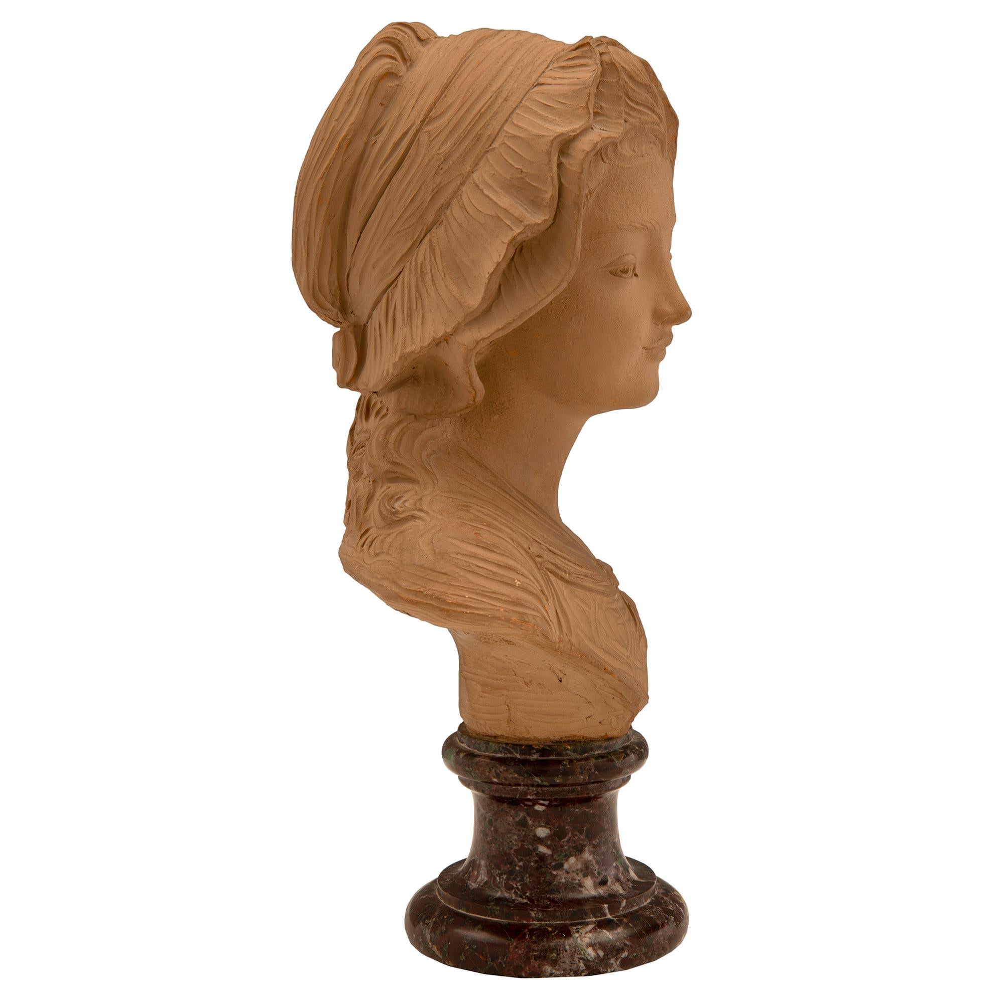 A charming and finely detailed French 19th century Terra Cotta and Rosso Levanto marble bust. The bust is raised by an elegant circular mottled Rosso Levanto socle pedestal with a fine mottled border. Above is the wonderfully executed terra cotta